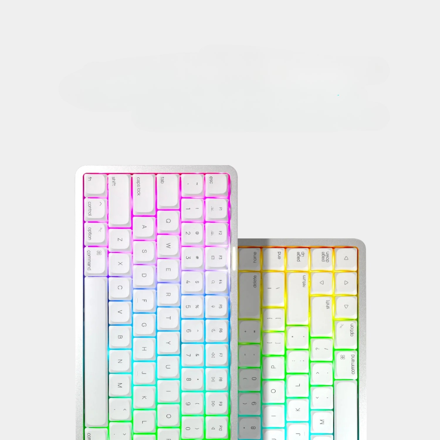 Dwie kompaktowe klawiatury z białymi obudowami i kolorowym podświetleniem RGB na jasnym tle.