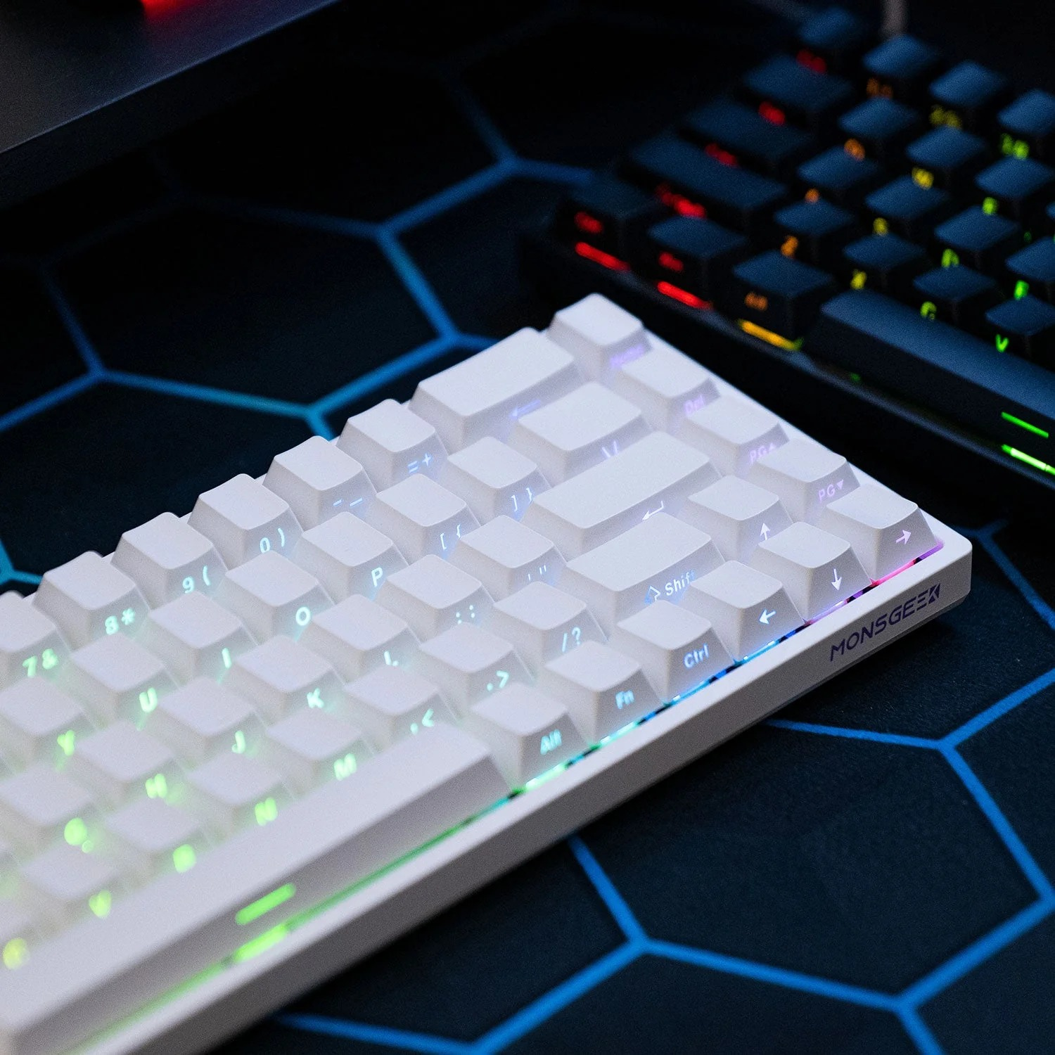 Biała klawiatura mechaniczna z podświetleniem RGB leży na niebieskiej podkładce.
