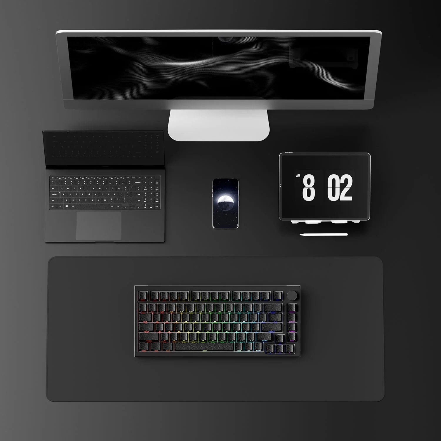 Minimalistyczne stanowisko pracy z monitorem, klawiaturami, smartfonem, tabletem i podkładką pod mysz w kolorze czarno-białym.