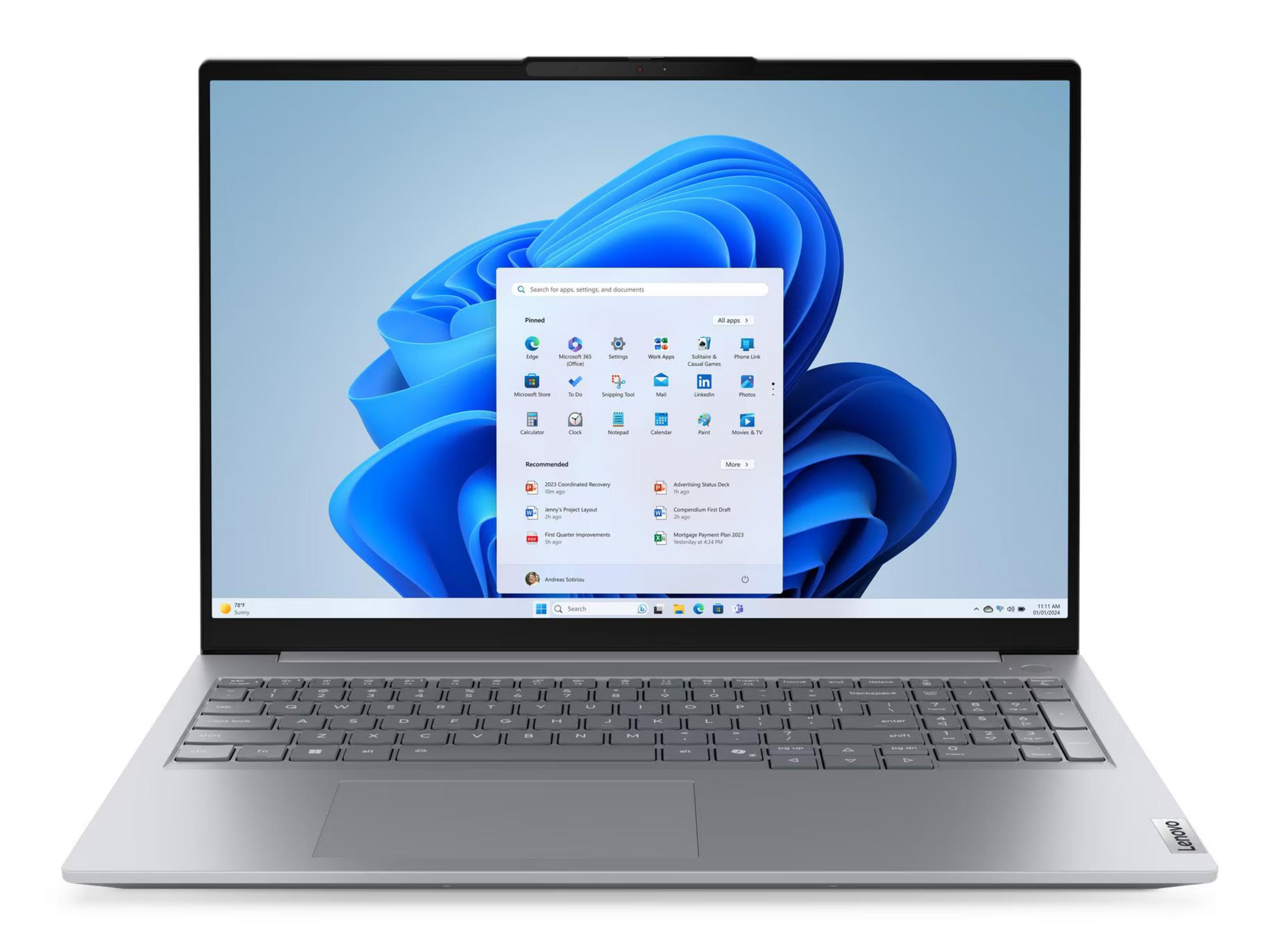 Srebrny laptop Lenovo wyświetla menu startowe systemu Windows 11 na niebieskim tle.