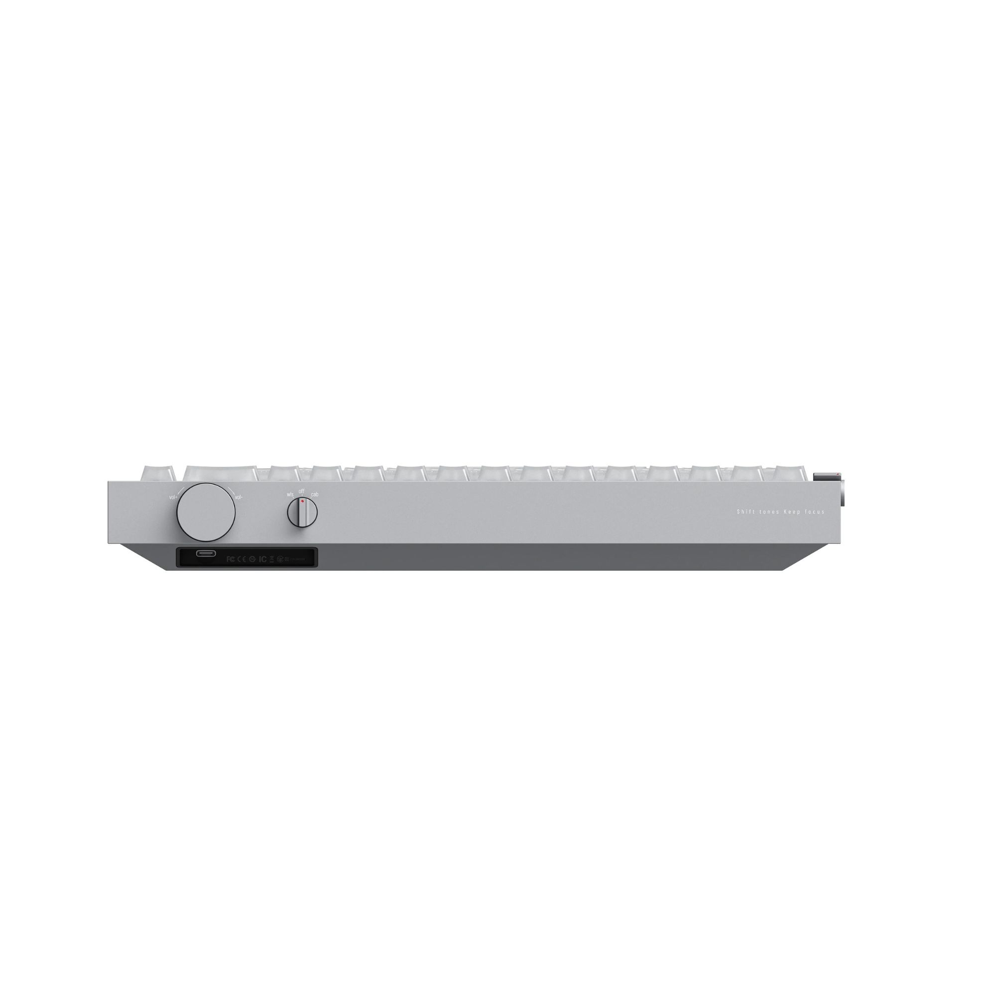 Srebrna klawiatura z pokrętłem głośności, przełącznikiem trybów i przednim portem USB.