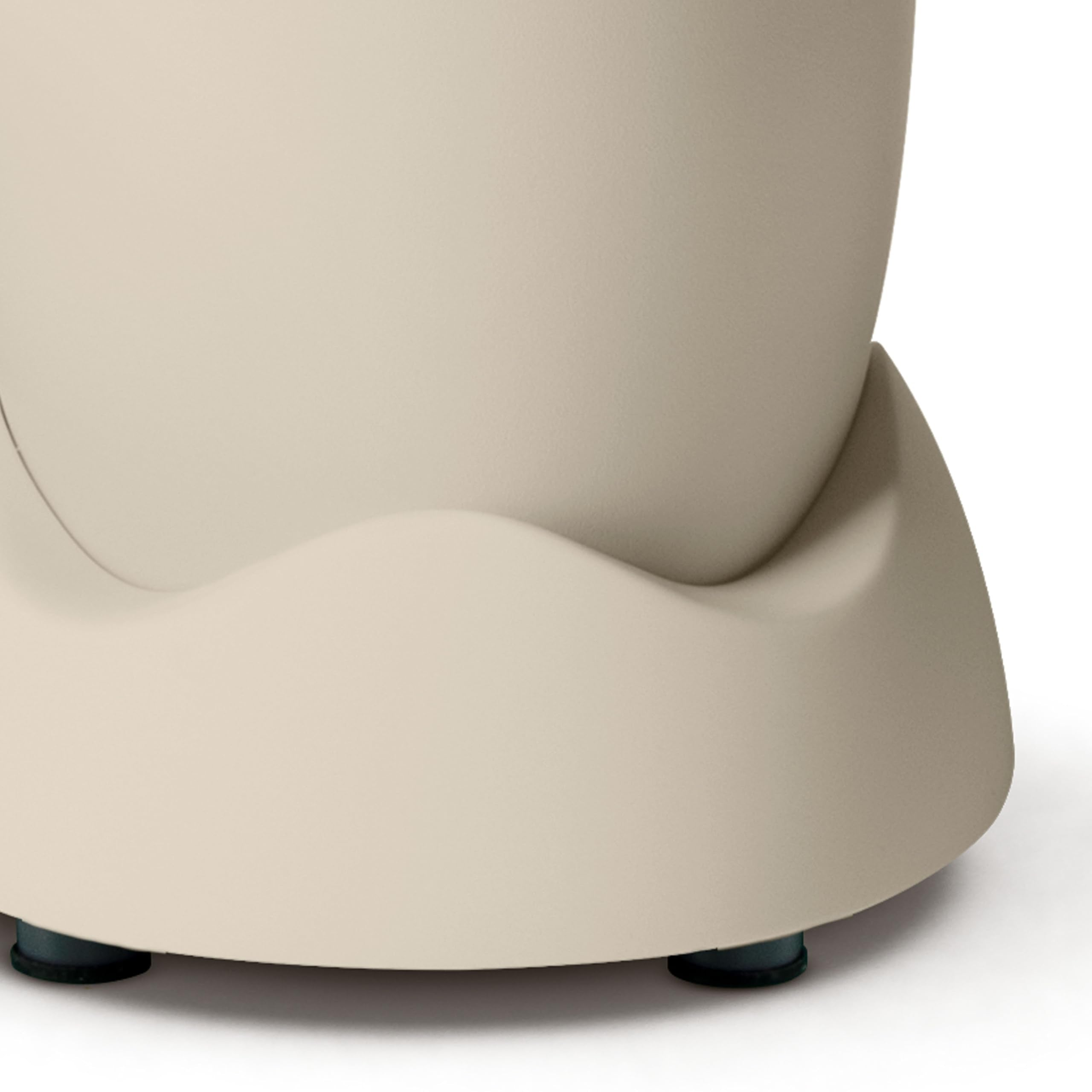 Beige, abgerundete Basis eines Haushaltsgeräts auf kleinen schwarzen Füßen vor weißem Hintergrund.