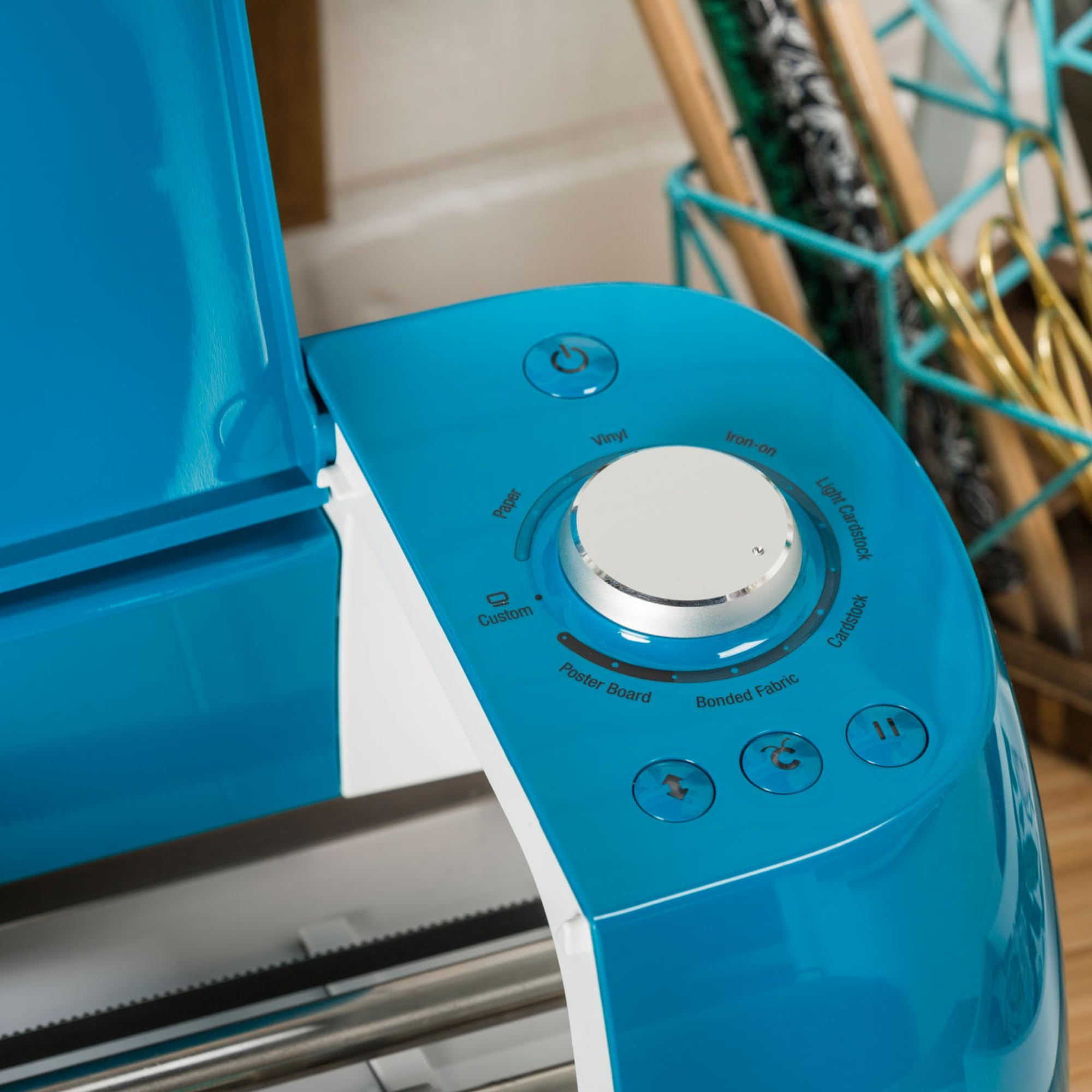 Gros plan sur le panneau de commande d'une machine de découpe bleue avec une molette argentée.