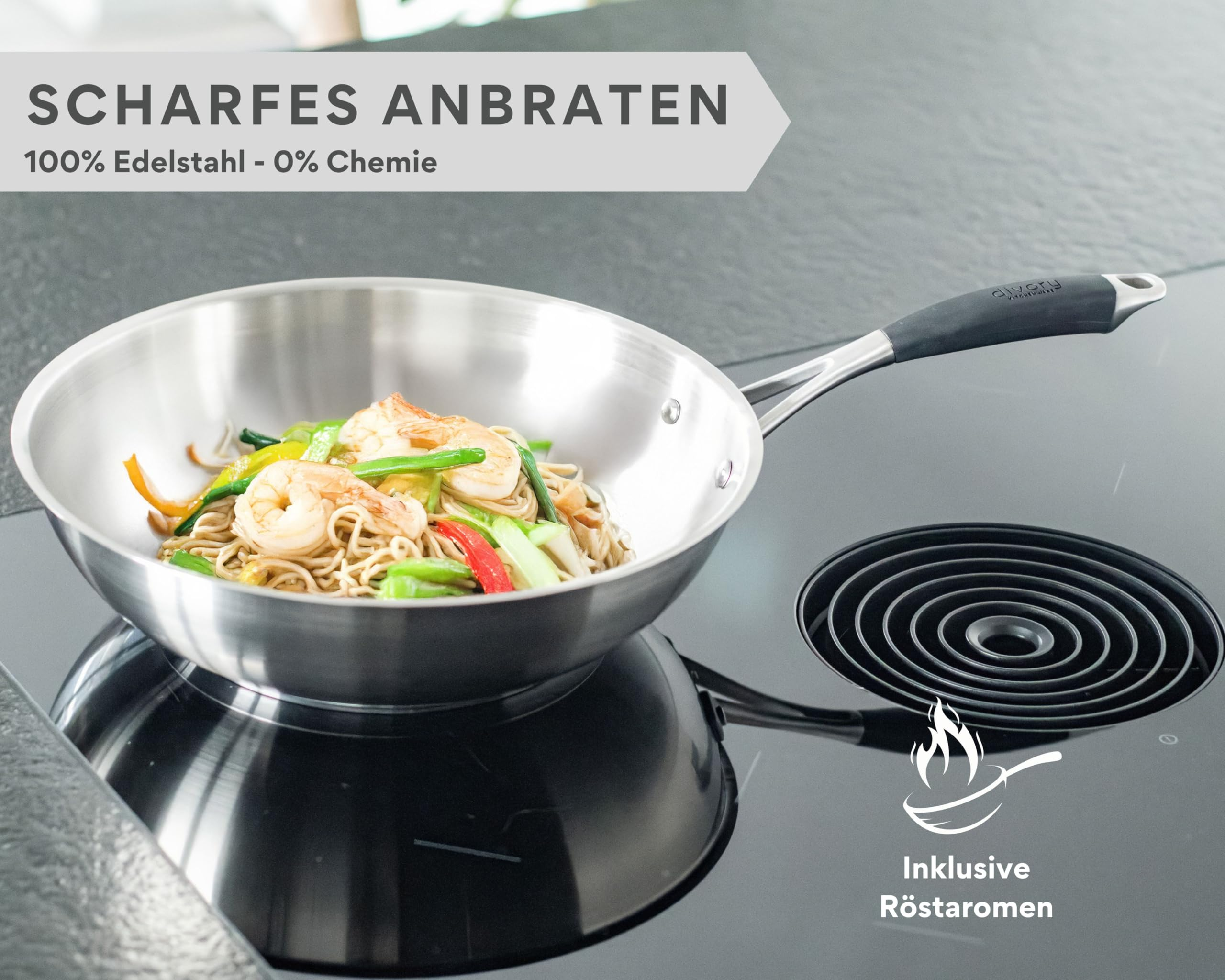 Une poêle en acier inoxydable avec des nouilles et des crevettes sur une table de cuisson noire.