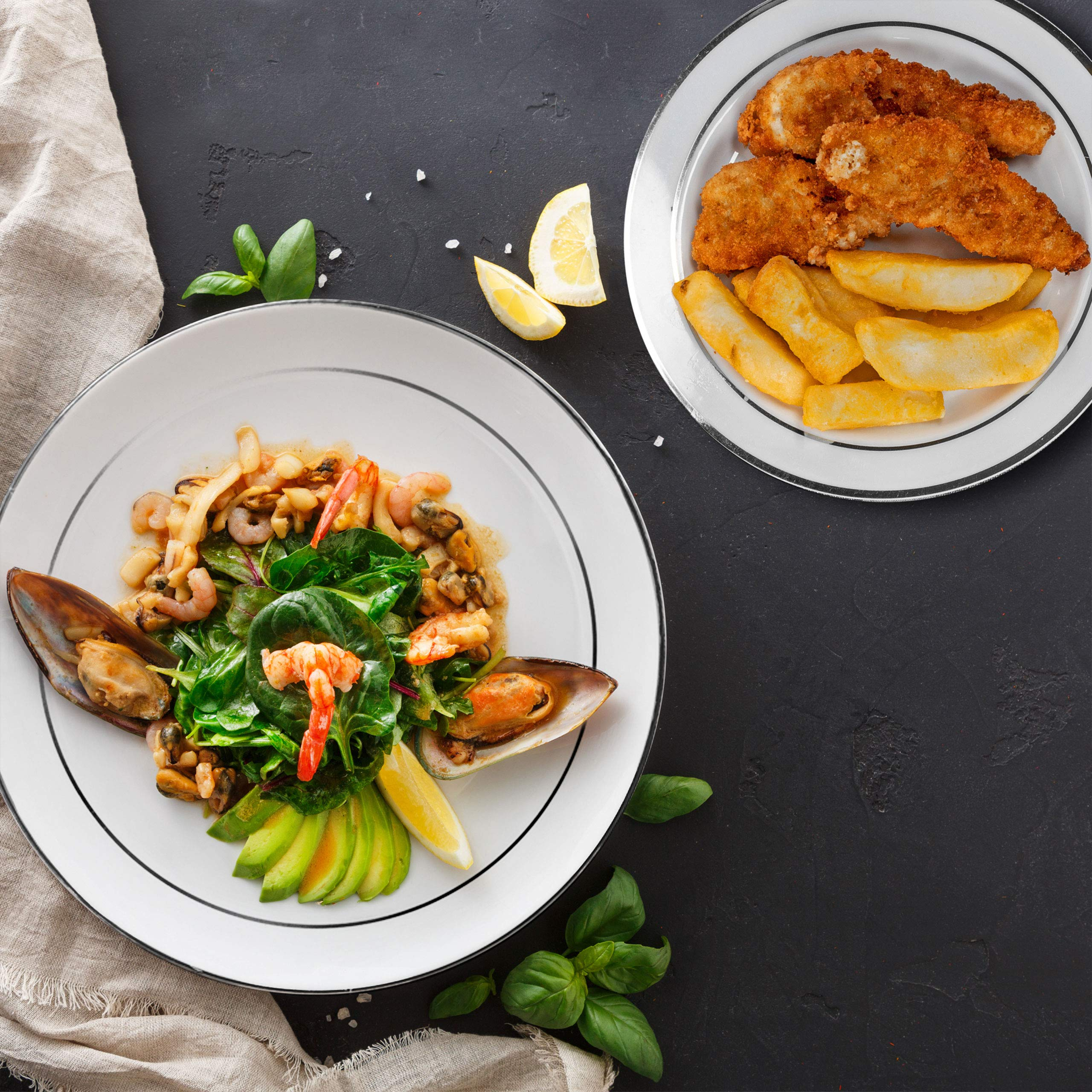 Insalata di frutti di mare con spinaci e cozze, e un piatto di pesce fritto con patatine.