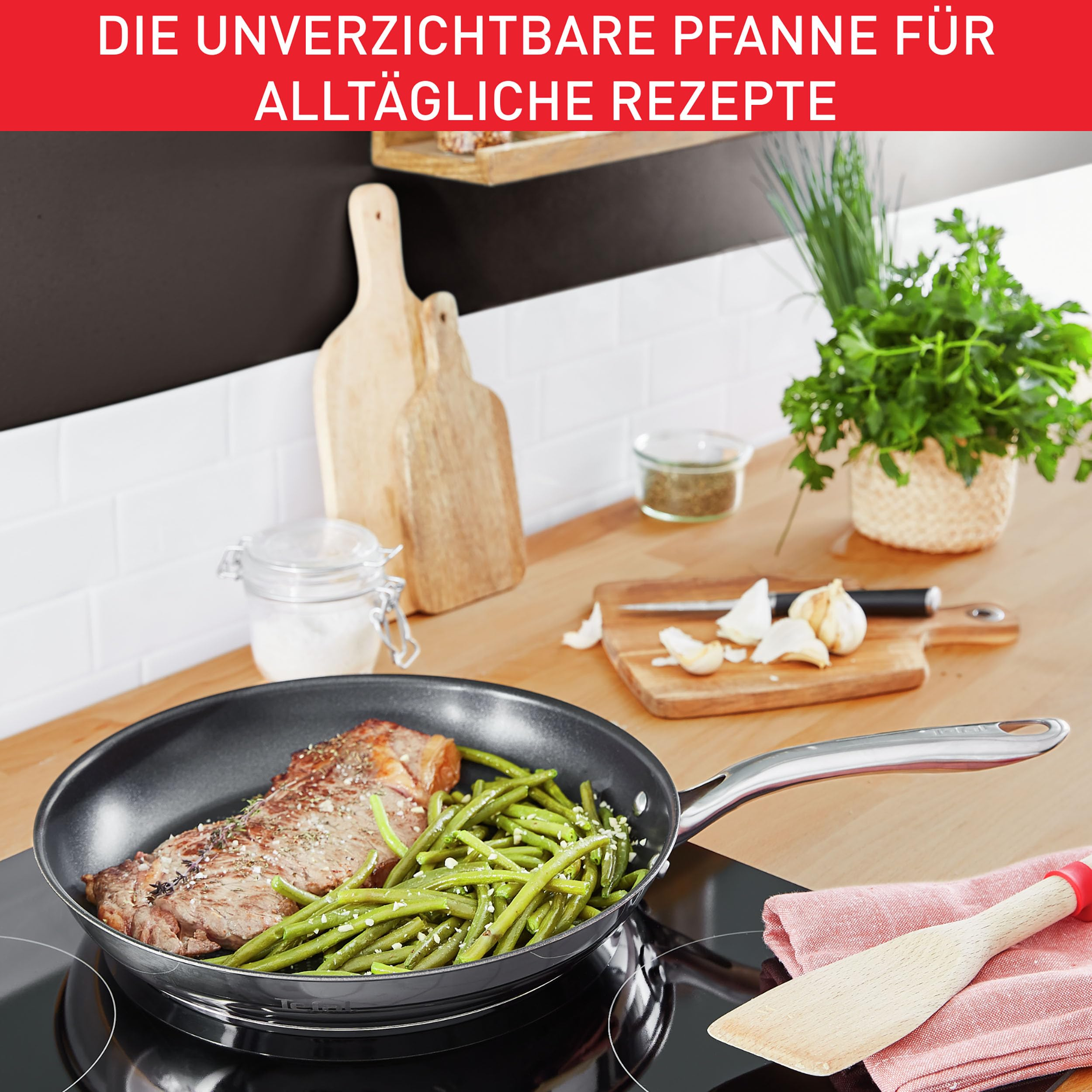 Steak et haricots verts cuisant dans une poêle sur une cuisinière avec des herbes en arrière-plan.
