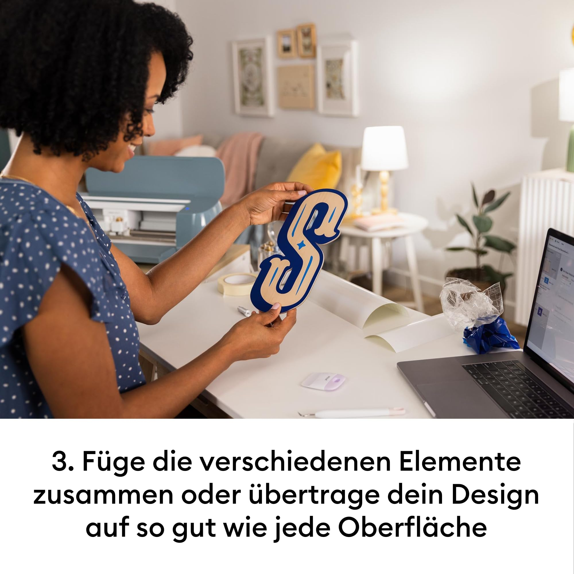 Une femme tient une lettre S en papier bleu à un bureau avec un ordinateur portable et des outils.