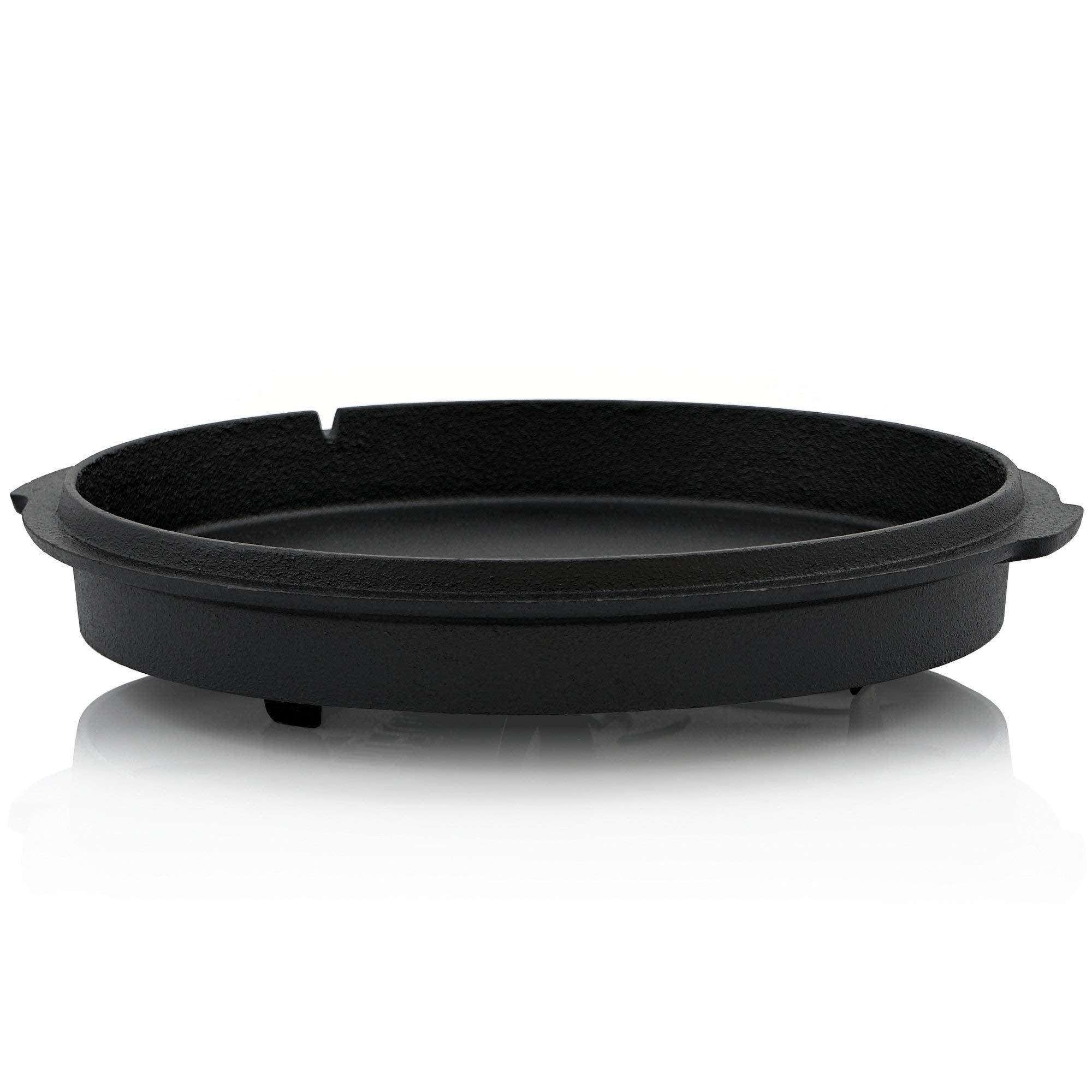 Poêle en fonte noire, ronde, à fond plat et aux bords bas sur fond blanc.