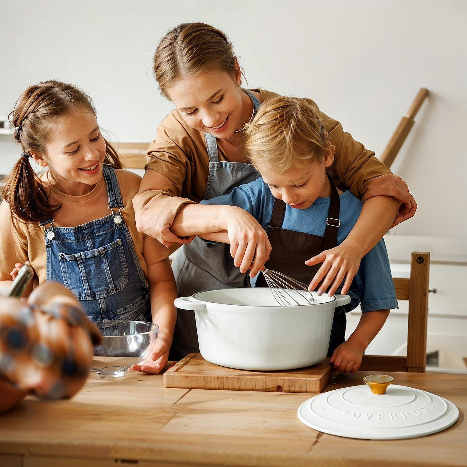 Una madre e due bambini cucinano insieme in una cucina luminosa su un tavolo di legno.