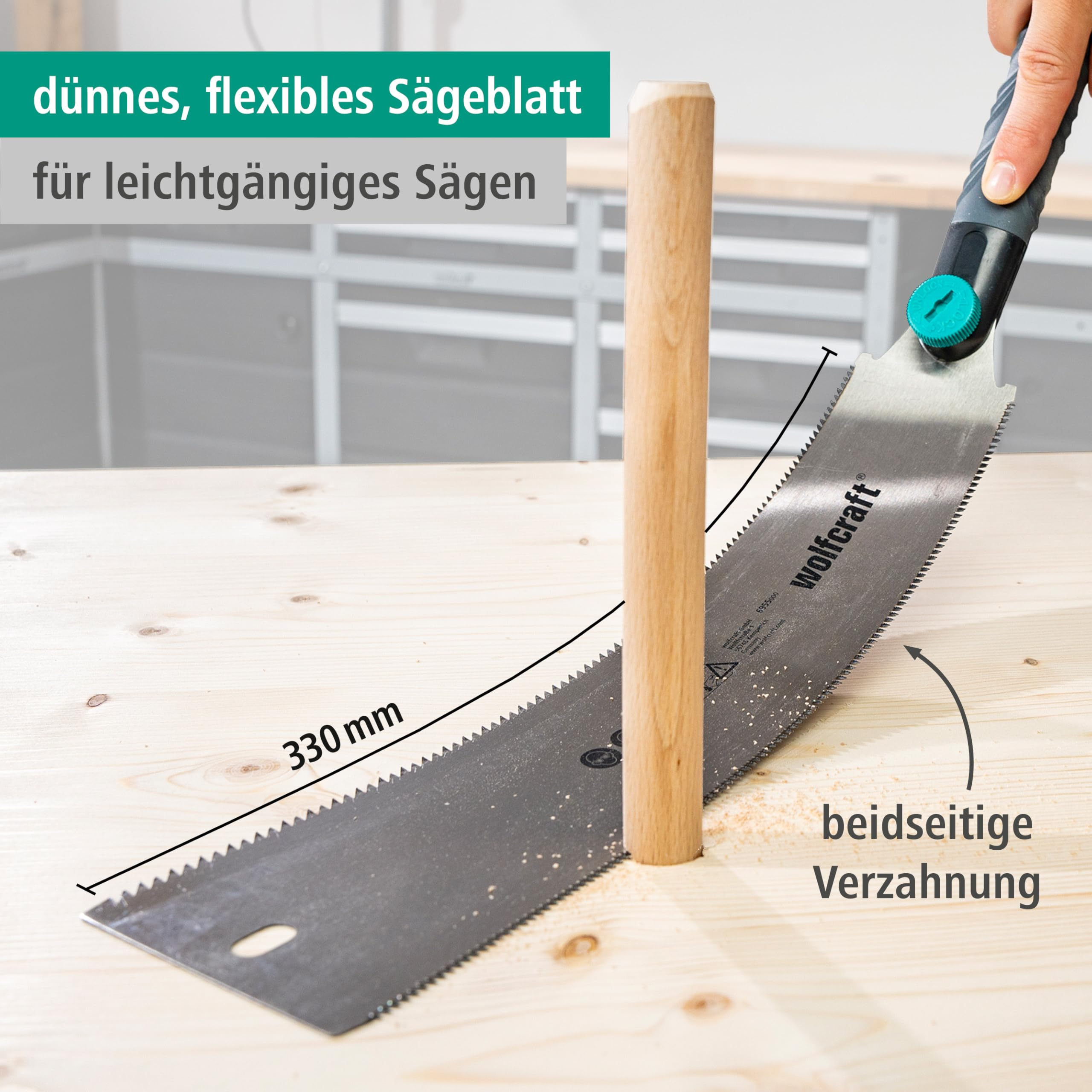 Eine flexible japanische Zugsaege schraegt einen Holzduebel auf einem Tisch ab, 330 mm Laenge.