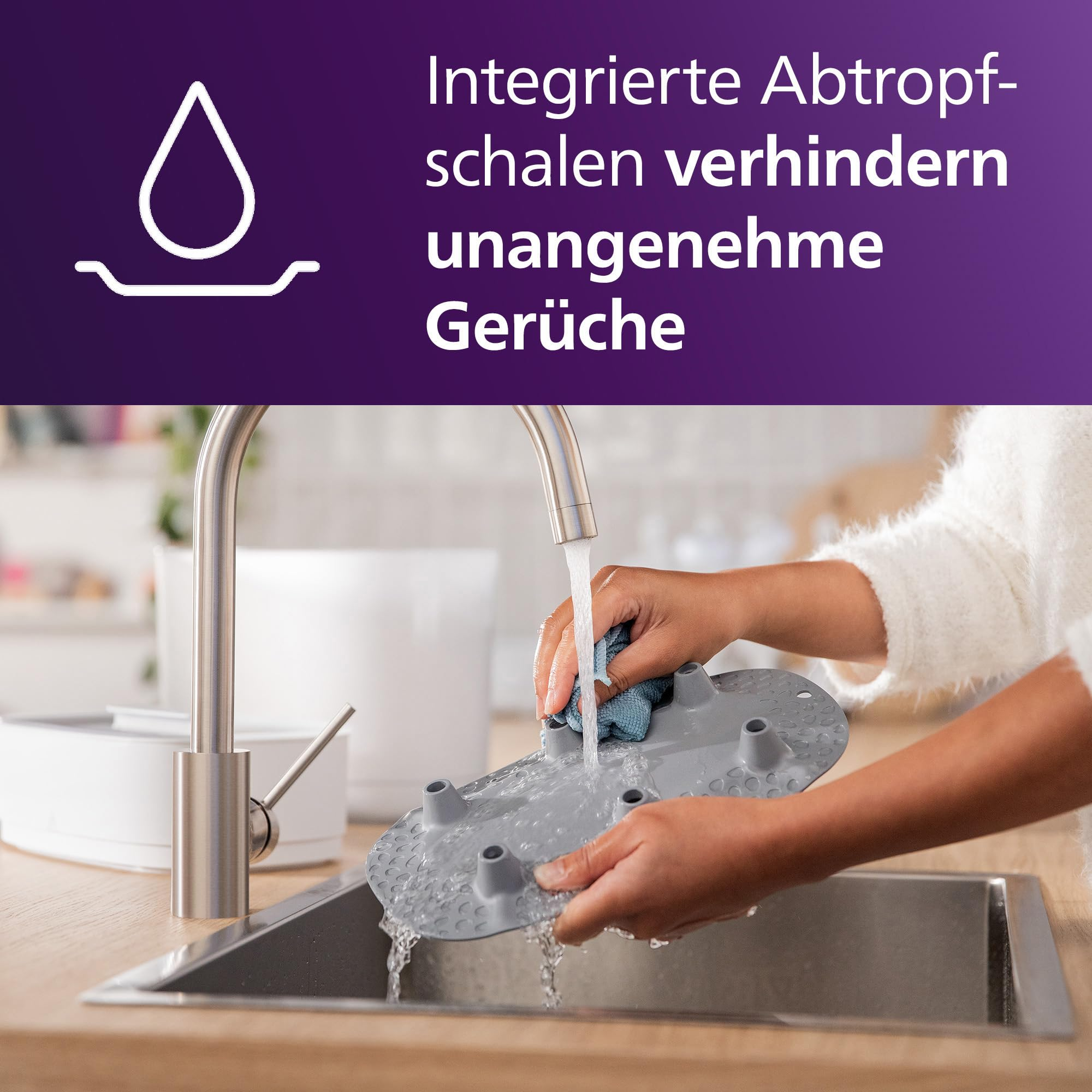 Person wäscht eine graue Abtropfschale unter dem Wasserhahn in einer Edelstahlspüle.