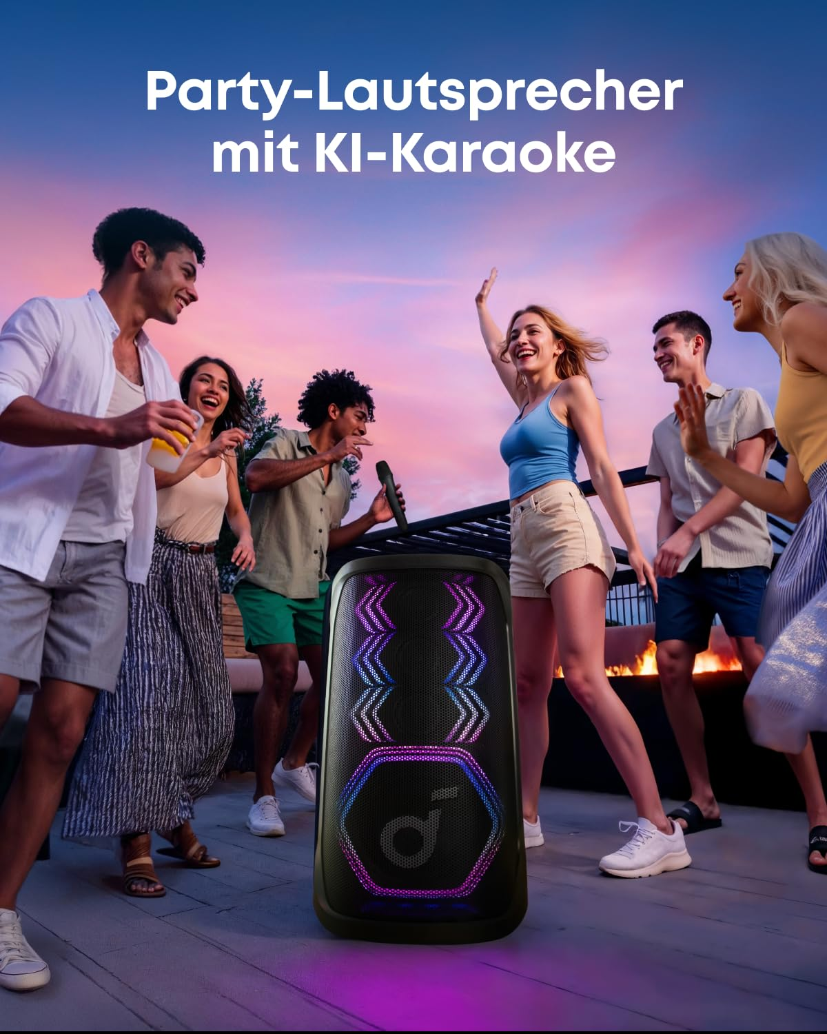 Des amis célèbrent à l'extérieur au coucher du soleil autour d'une enceinte de fête lumineuse.