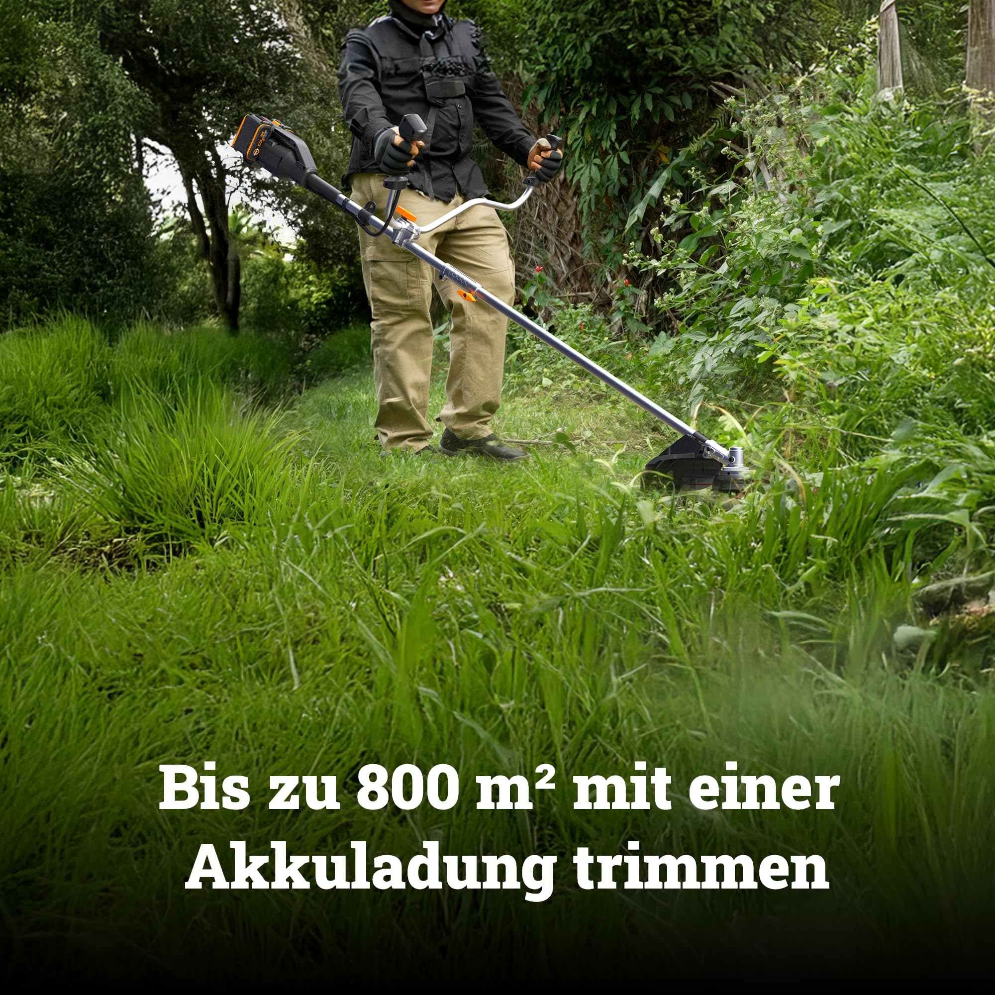 Una persona usa un decespugliatore a batteria in un giardino verde e incolto con alberi sullo sfondo.