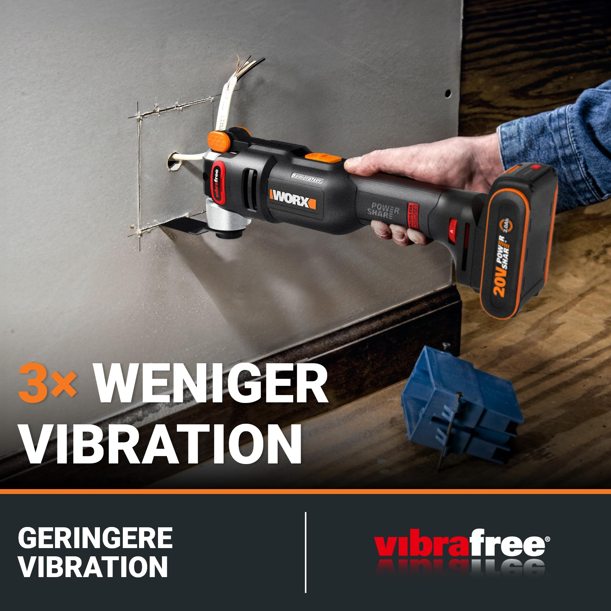 Une main utilise un outil oscillant Worx noir et orange pour couper du placo.