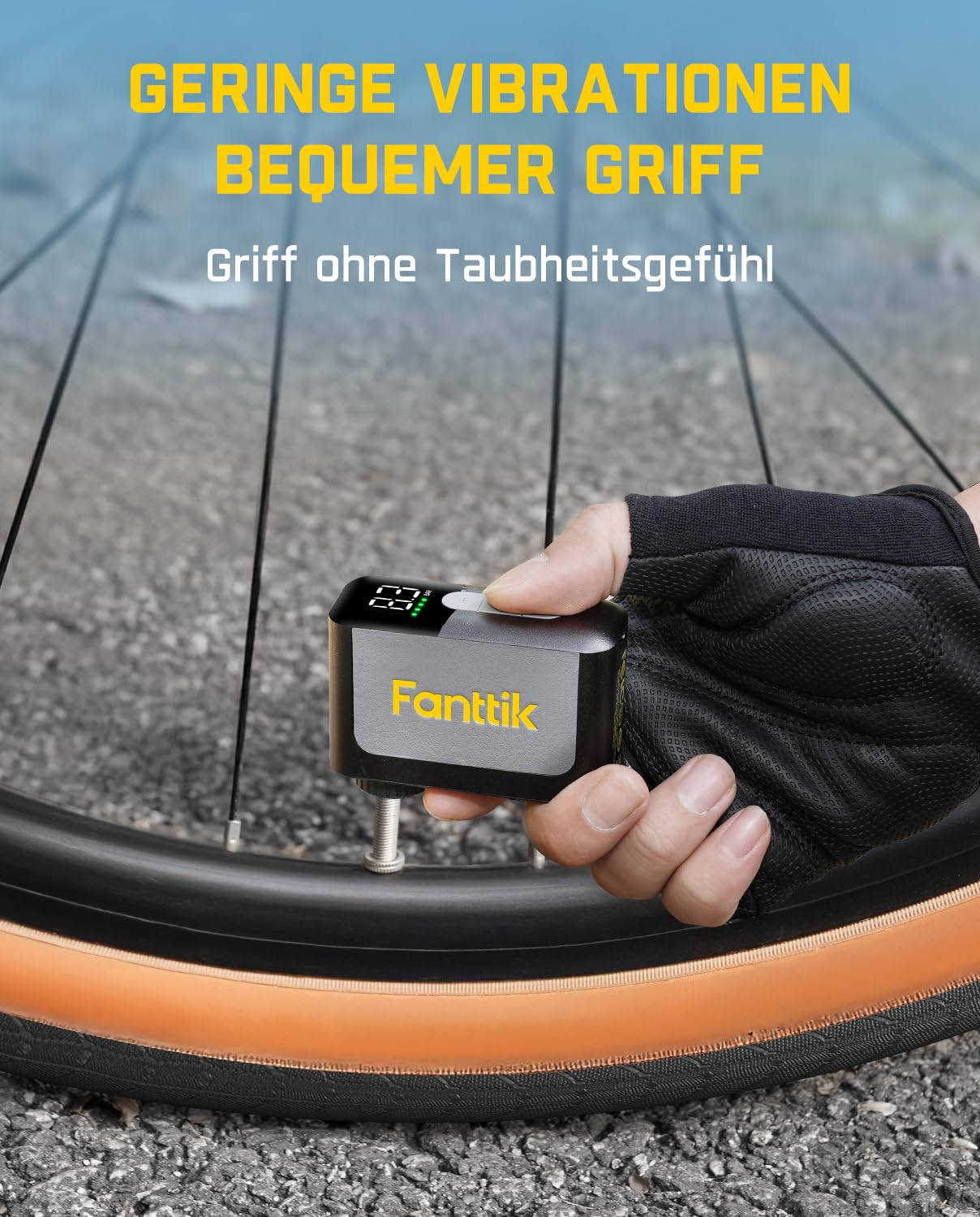 Una mano guantata tiene un piccolo dispositivo nero Fanttik collegato alla valvola di uno pneumatico di bicicletta.