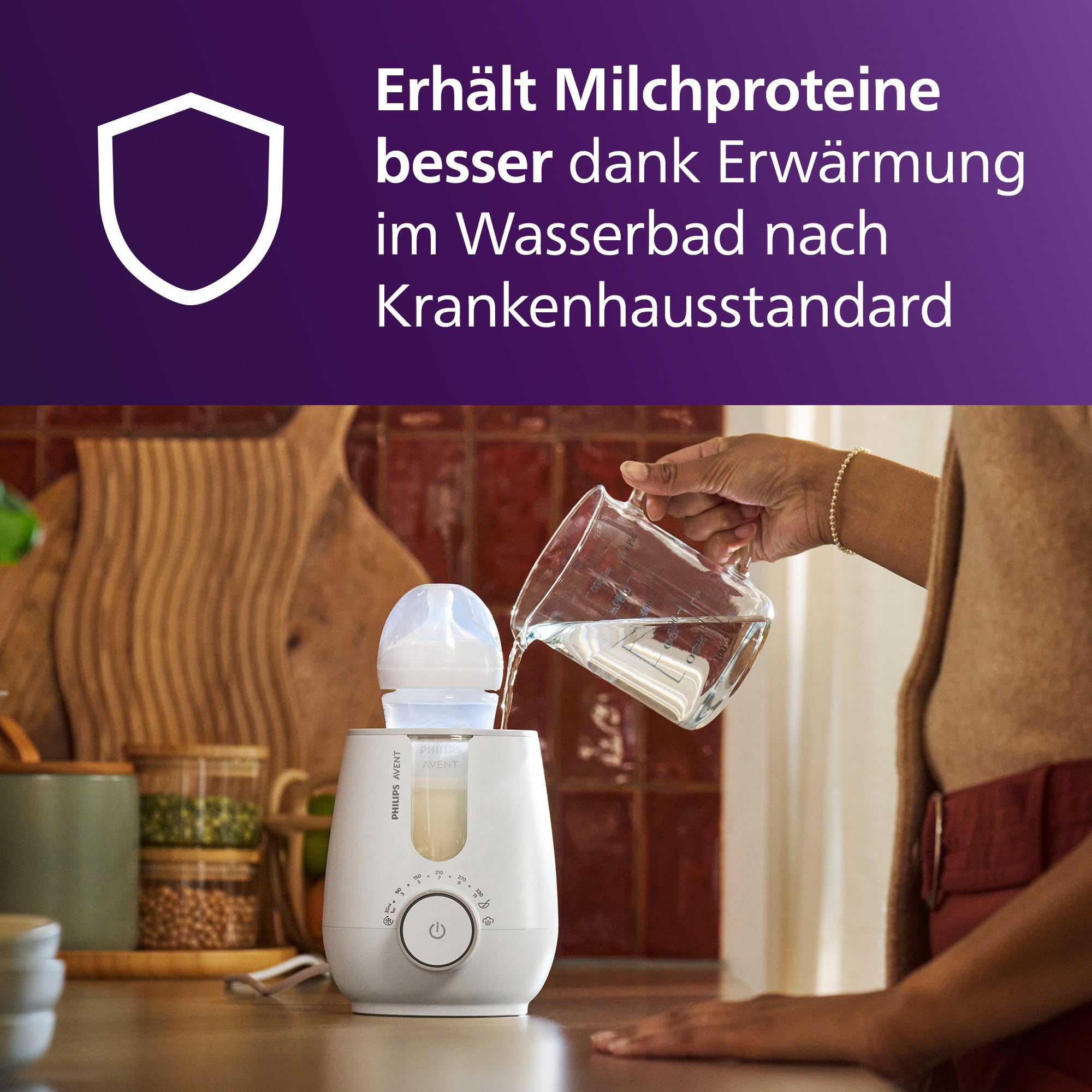 Una persona versa dell'acqua in uno scaldabiberon Philips Avent bianco su un bancone.