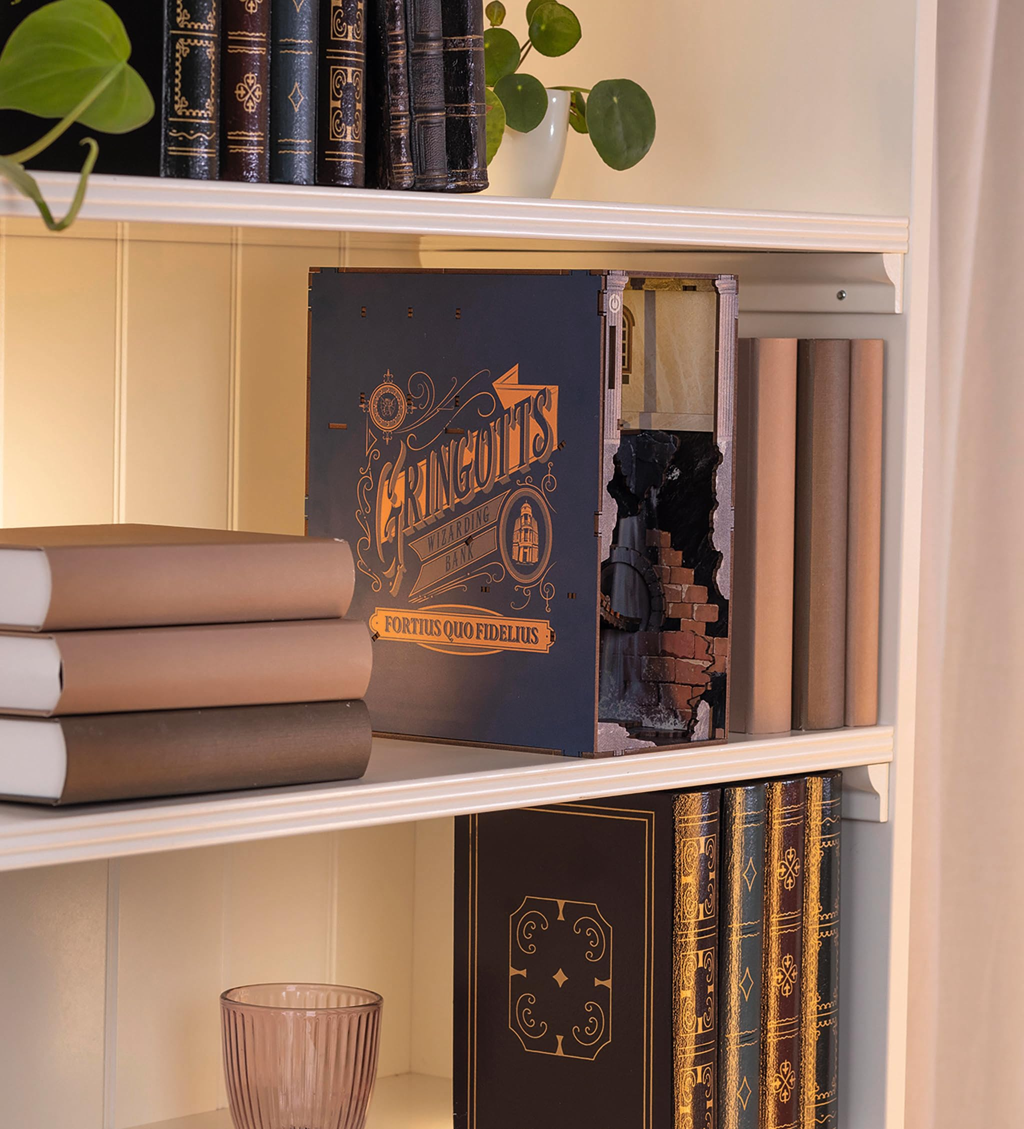 Ein blaues Buchnook mit Gringotts-Aufschrift steht auf einem Bücherregal, flankiert von Büchern.