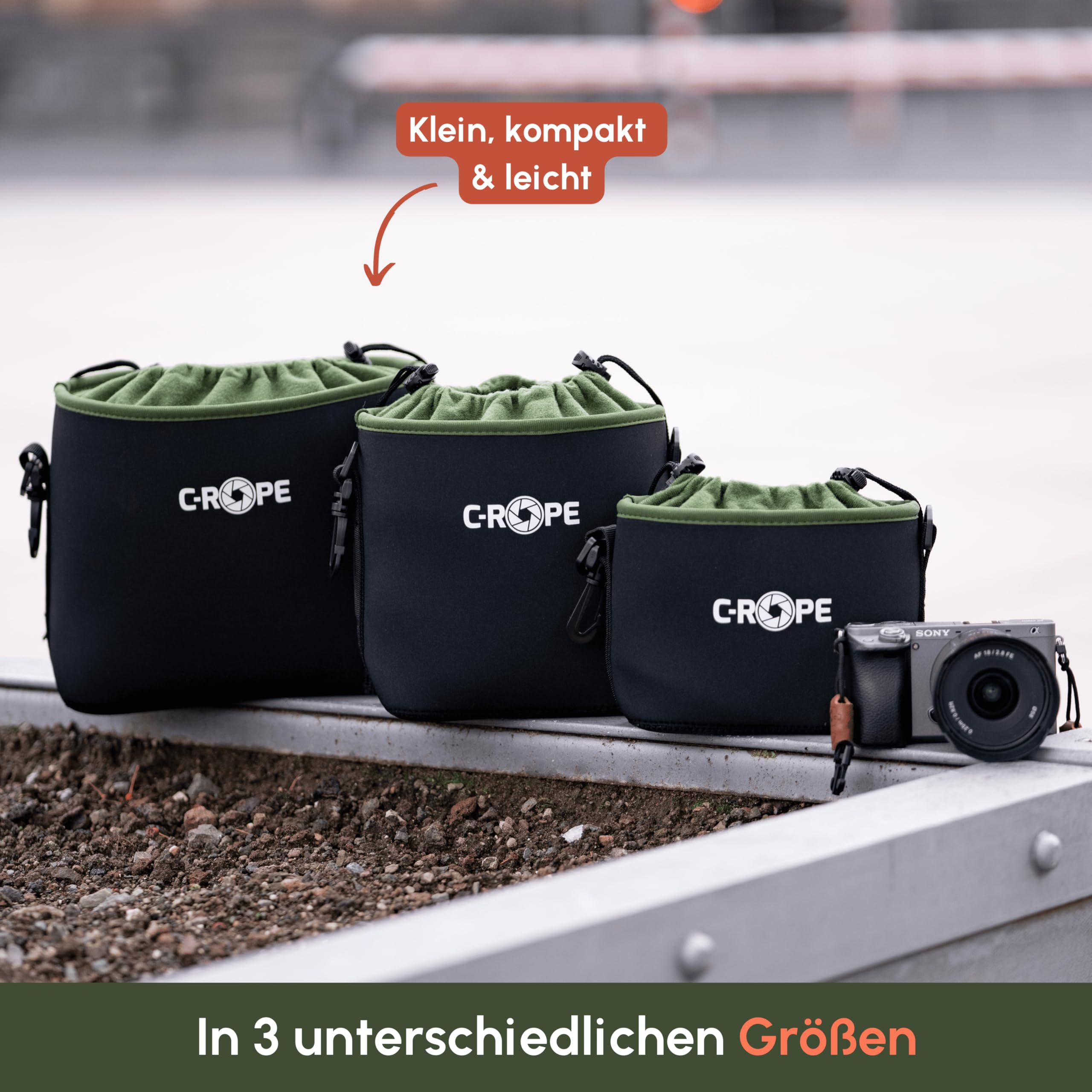 Drei schwarze C-Rope-Kamerataschen in verschiedenen Grössen mit grünem Innenfutter stehen draussen auf einer Kante.