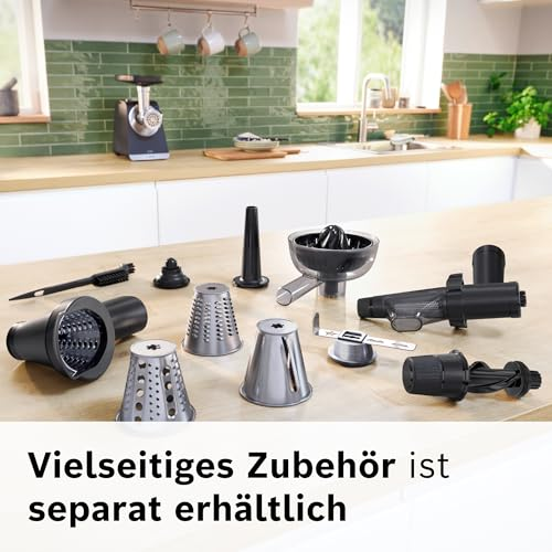 Verschiedene Küchenmaschinen-Zubehöre und Aufsätze liegen auf einer Holzarbeitsplatte in einer modernen Küche.