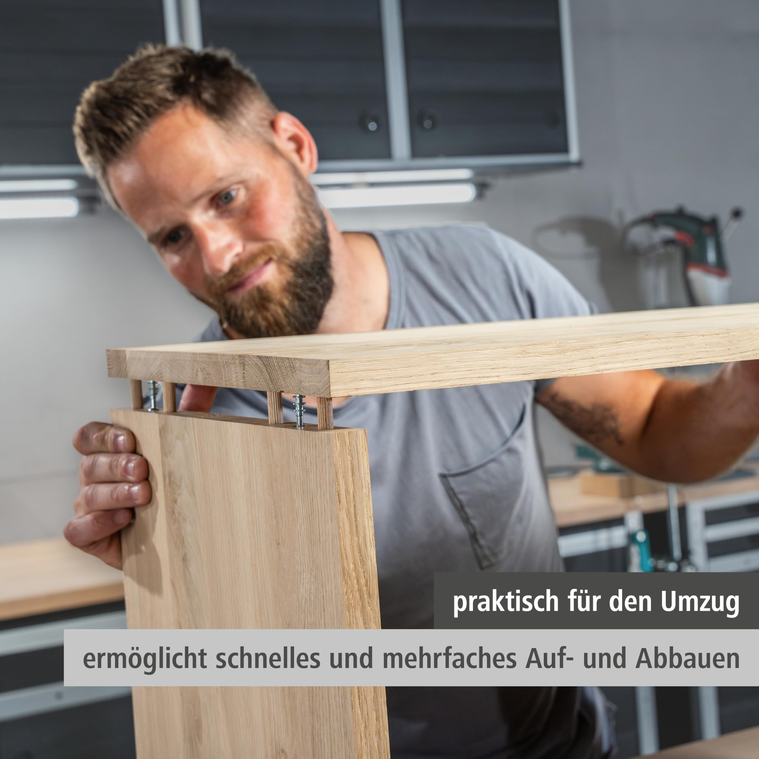 Ein Handwerker baut in einer Werkstatt ein Holzmöbel mit Holzdübeln zusammen.