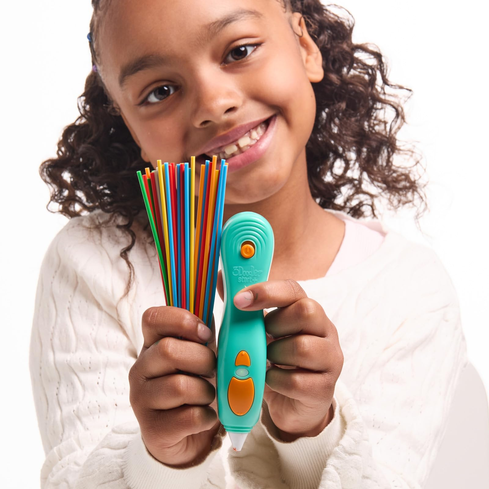 Une jeune fille souriante tient un stylo d'impression 3D bleu clair et des filaments en plastique colorés.