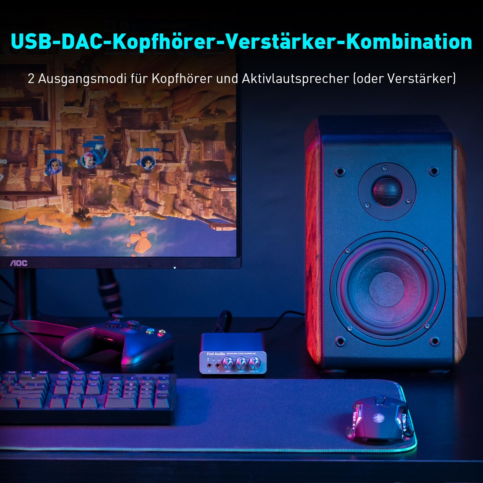 Gaming-Setup mit Monitor, Lautsprecher, Tastatur, Maus, Controller und Fosi Audio DAC auf dem Schreibtisch.