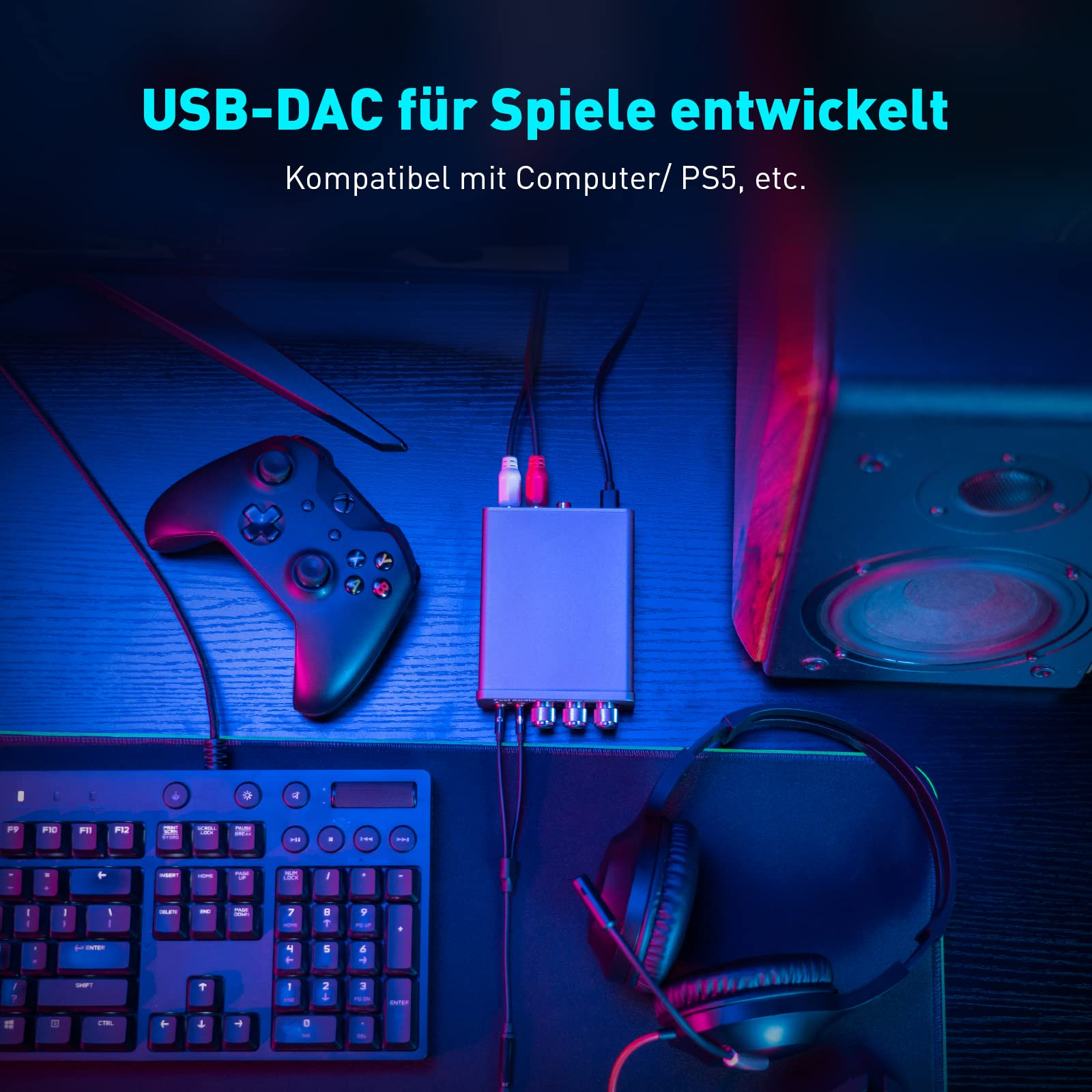 Gaming-USB-DAC auf Schreibtisch mit Controller, Tastatur, Kopfhörer und Lautsprecher in blauem Licht.