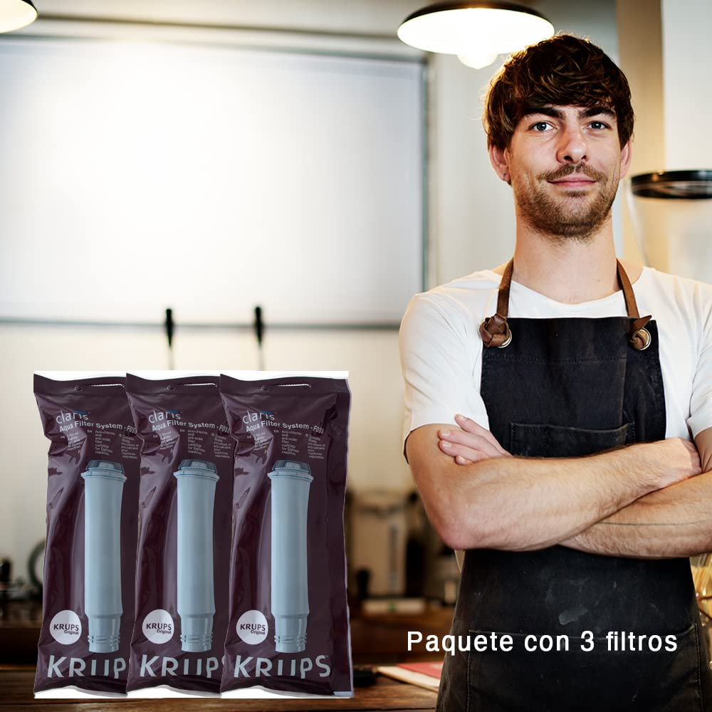 Un barista con le braccia conserte accanto a tre confezioni di filtri per acqua Krups Claris.