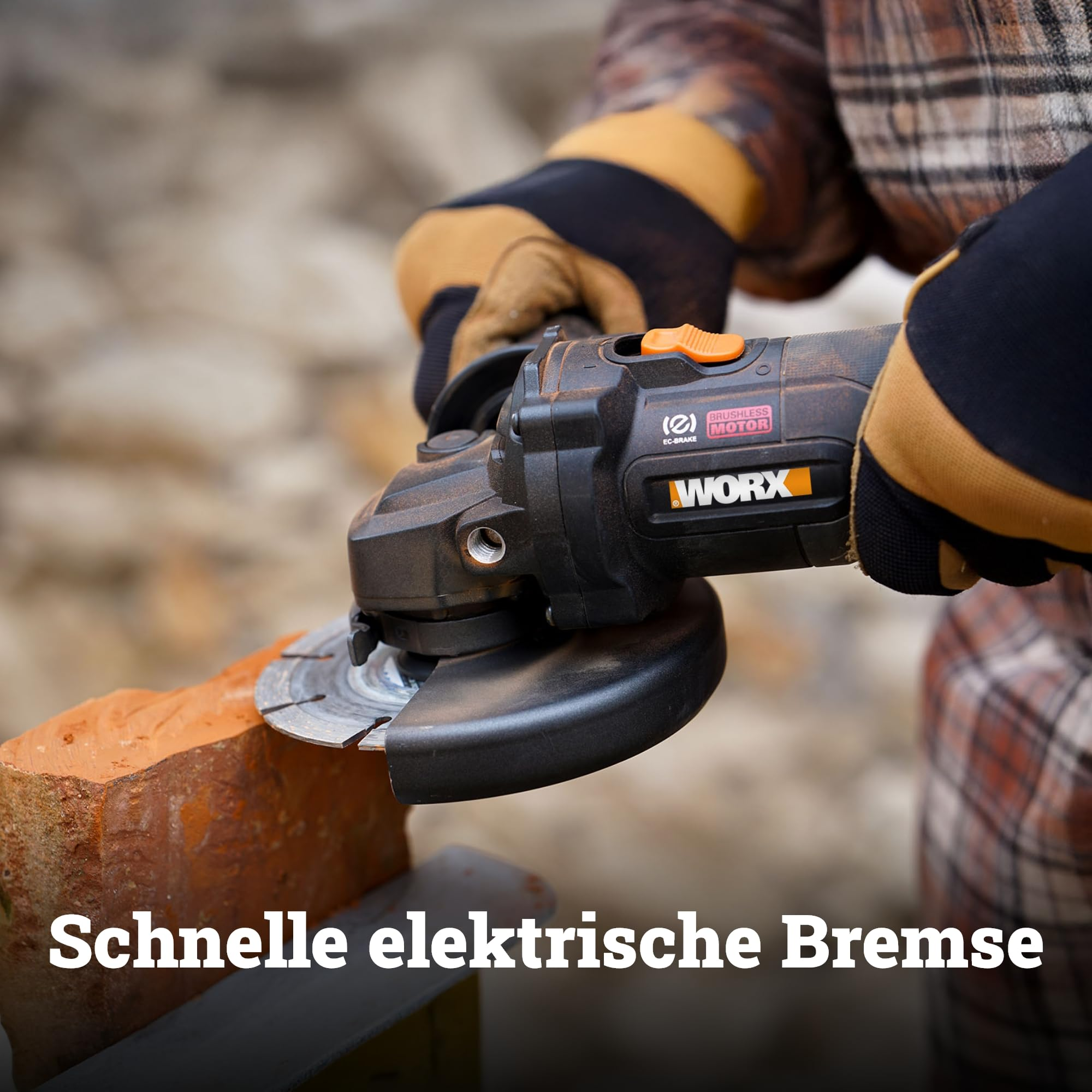 Eine Person mit Handschuhen hält eine schwarze Worx-Winkelschleifmaschine, die einen roten Ziegelstein schneidet.