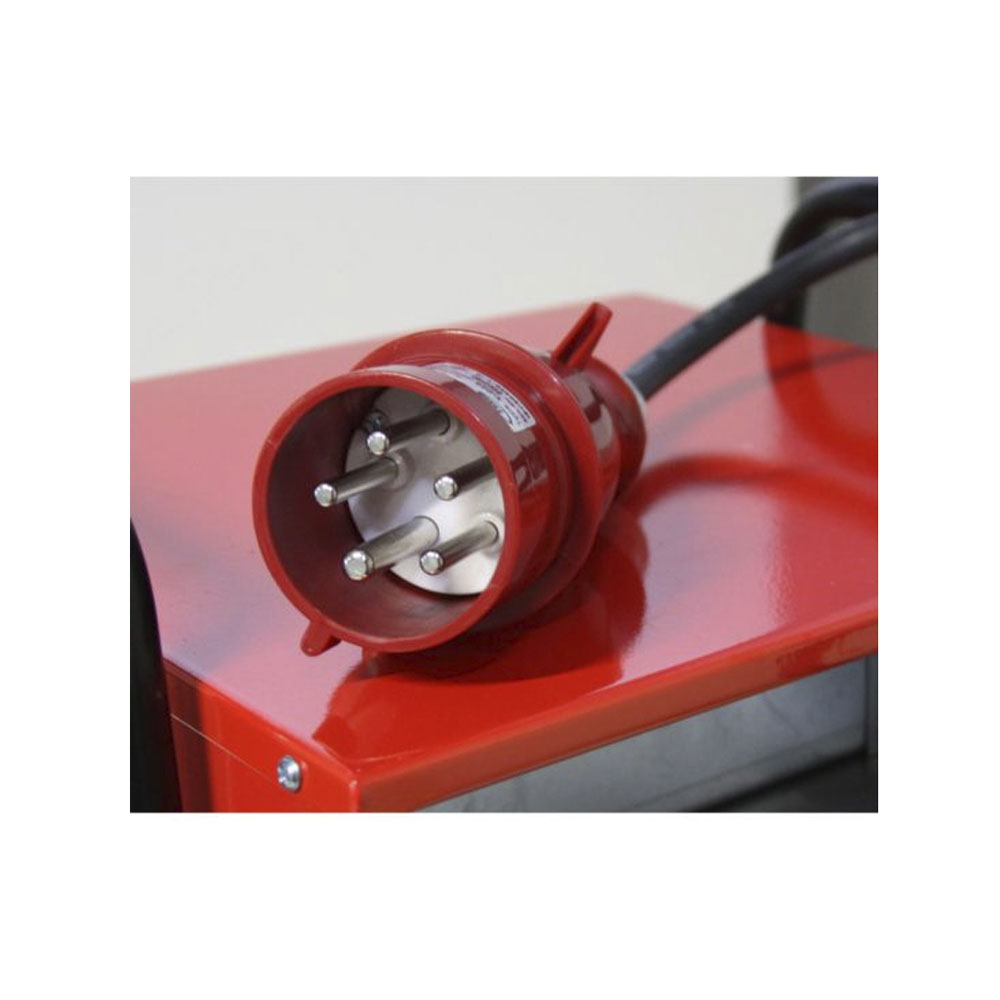 Roter, fünfpoliger Starkstromstecker auf roter Metalloberfläche.