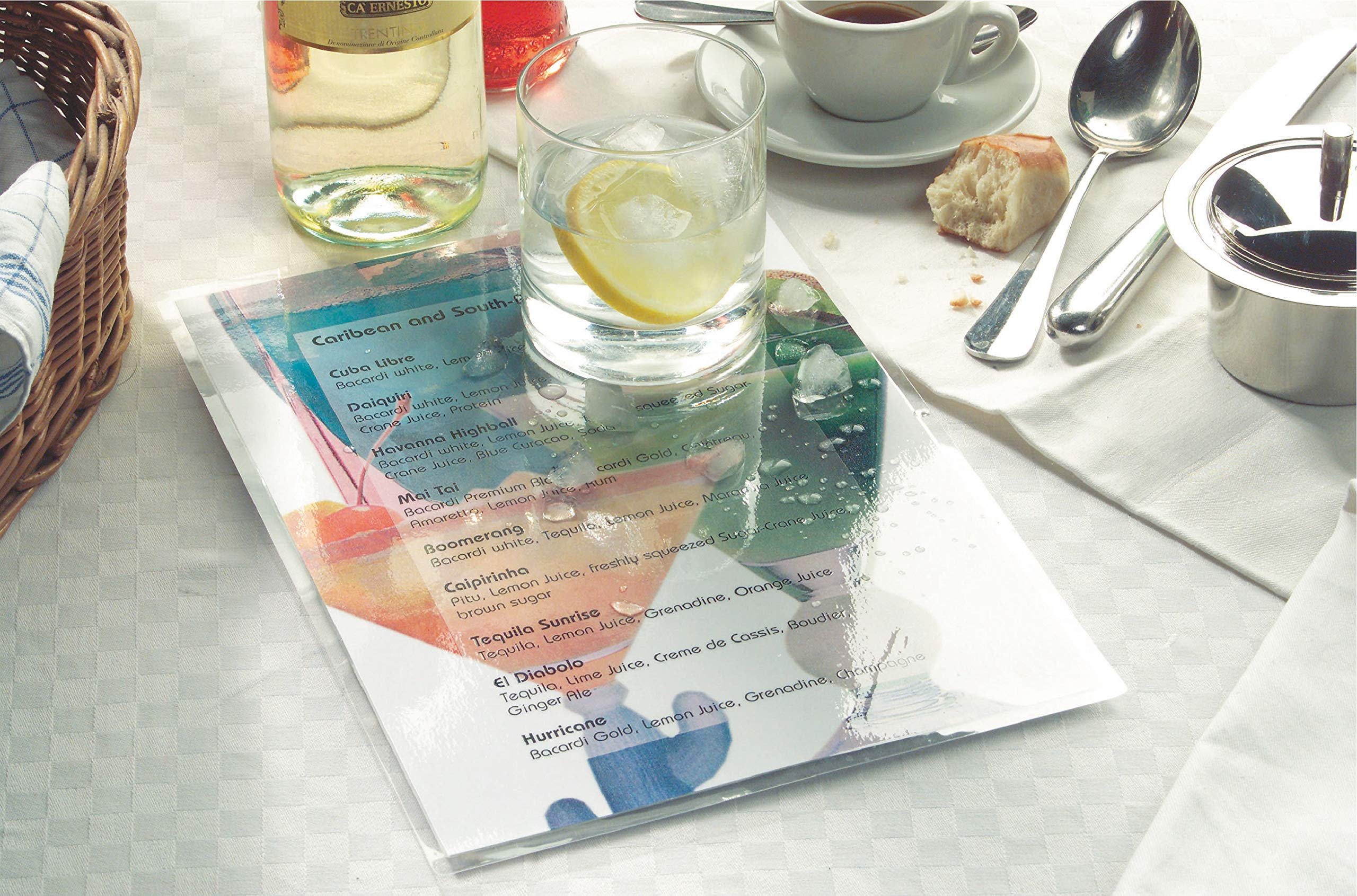 Carte des boissons sur une table dressée avec un verre d'eau, du vin, du café et des couverts.