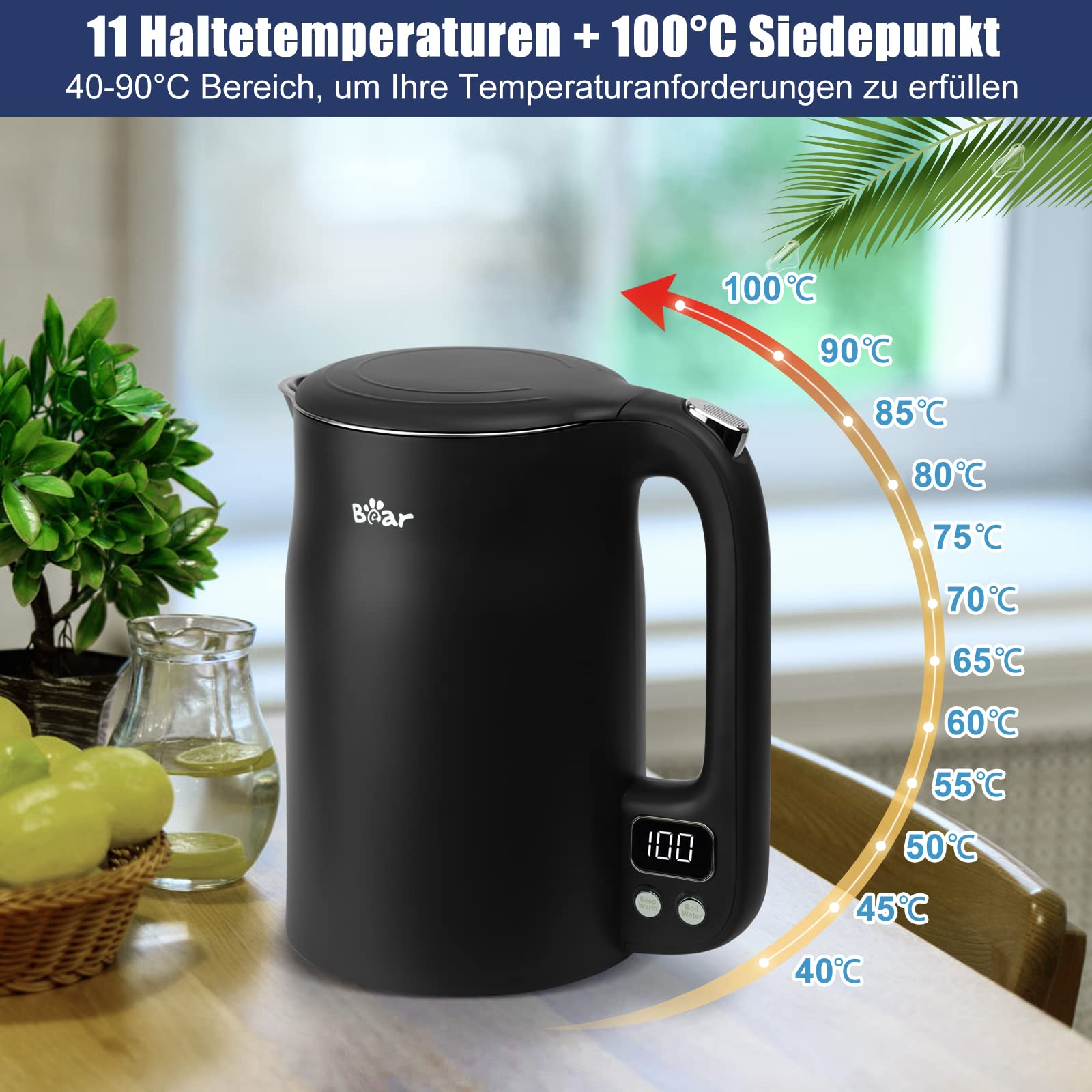 Bollitore elettrico nero con display della temperatura su un tavolo di legno, circondato da piante.
