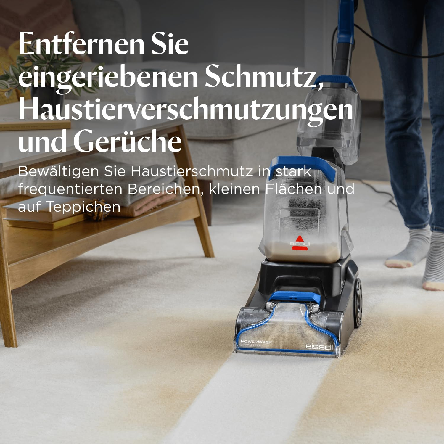 Un pulisci tappeti Bissell pulisce un tappeto sporco in un soggiorno con mobili in legno.