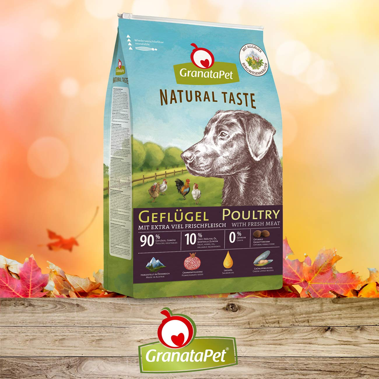 GranataPet Hundefutterbeutel mit Geflügel, Hunde- und Hühnermotiven, vor Herbstlaub und Holz.