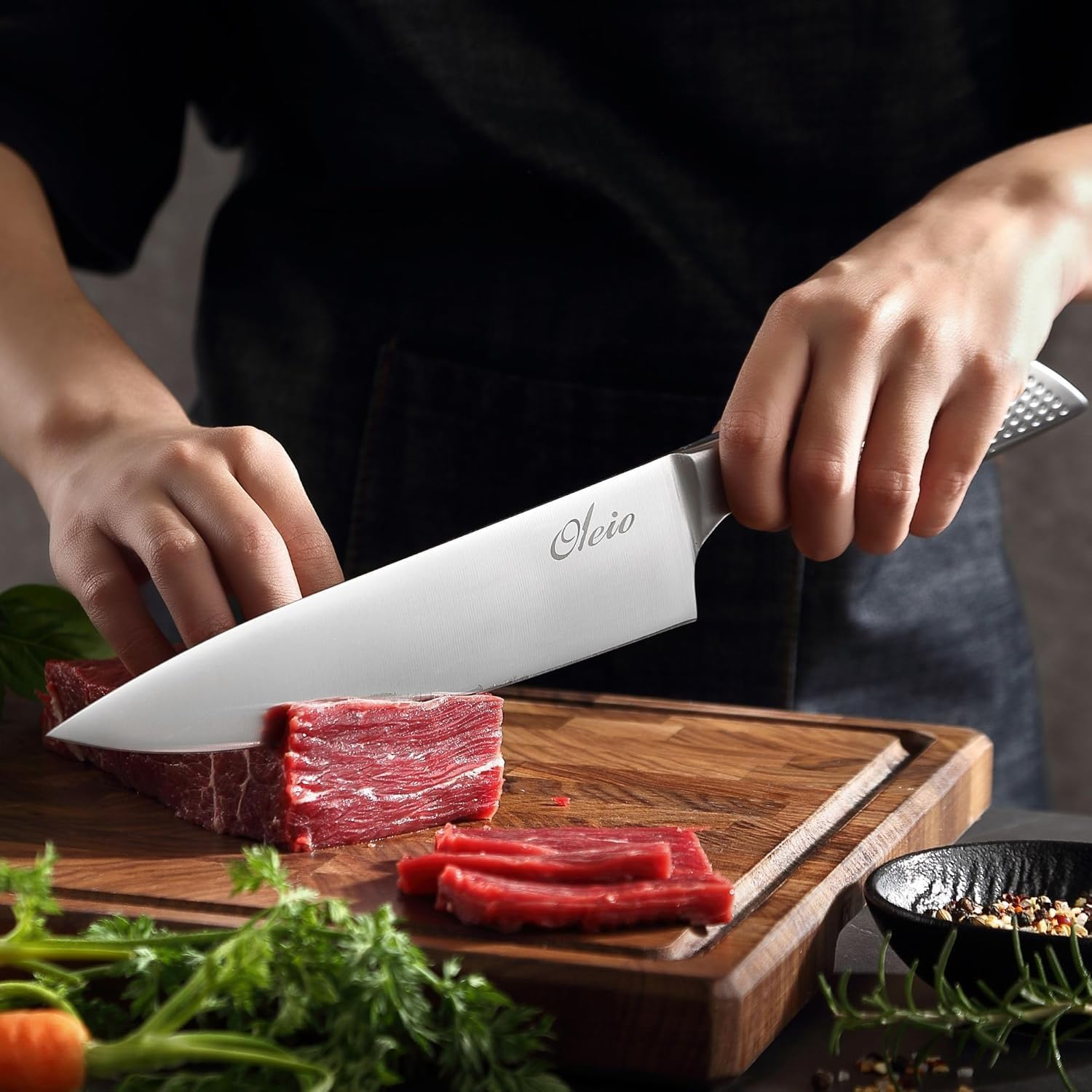 Ein Koch schneidet rohes Rindfleisch auf einem Holzbrett mit einem Oleio-Messer, Kräuter und Gewürze.