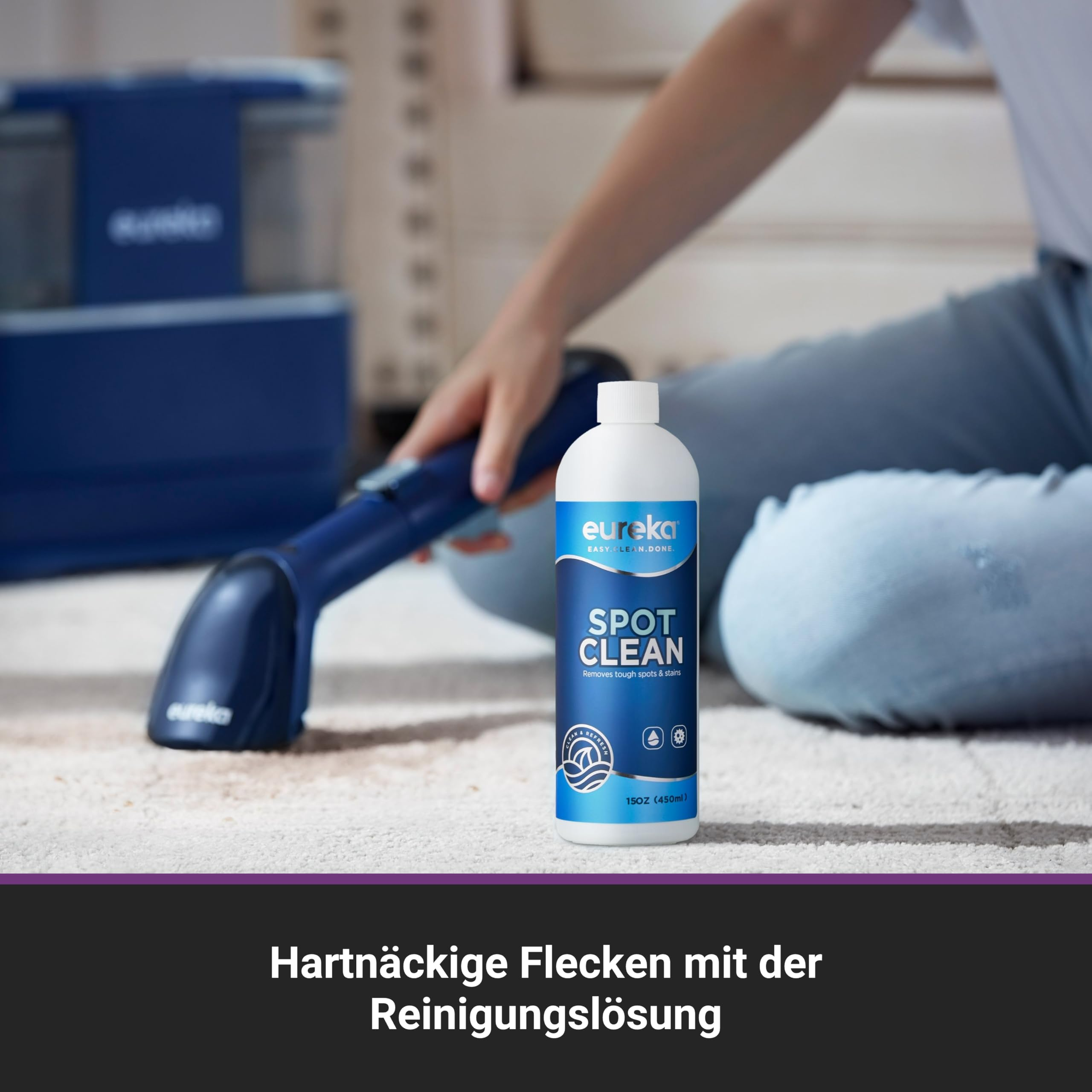 Una bottiglia di soluzione detergente Eureka Spot Clean su un tappeto mentre qualcuno usa un pulitore blu.