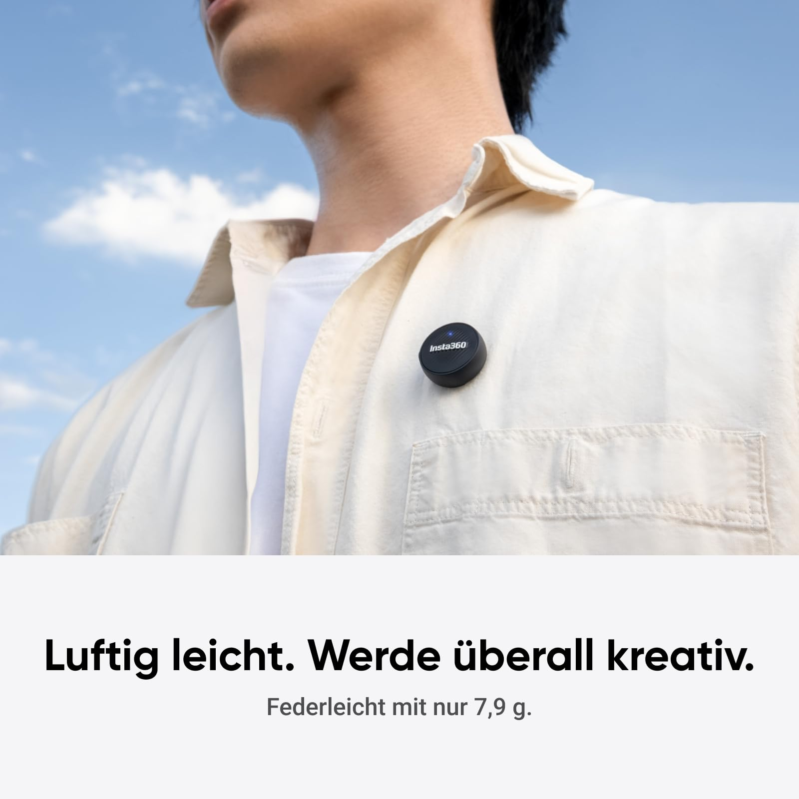 Ein Mensch in heller Kleidung trägt einen kleinen schwarzen Insta360-Clip an der Brust vor blauem Himmel.