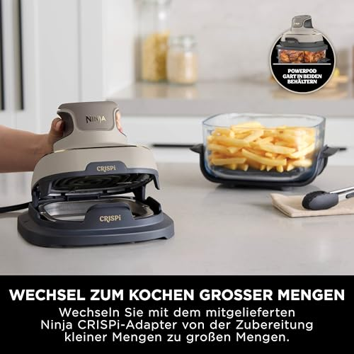 Une main place le powerpod Ninja CRISPi sur une base, à côté d'un plat de frites sur un comptoir.