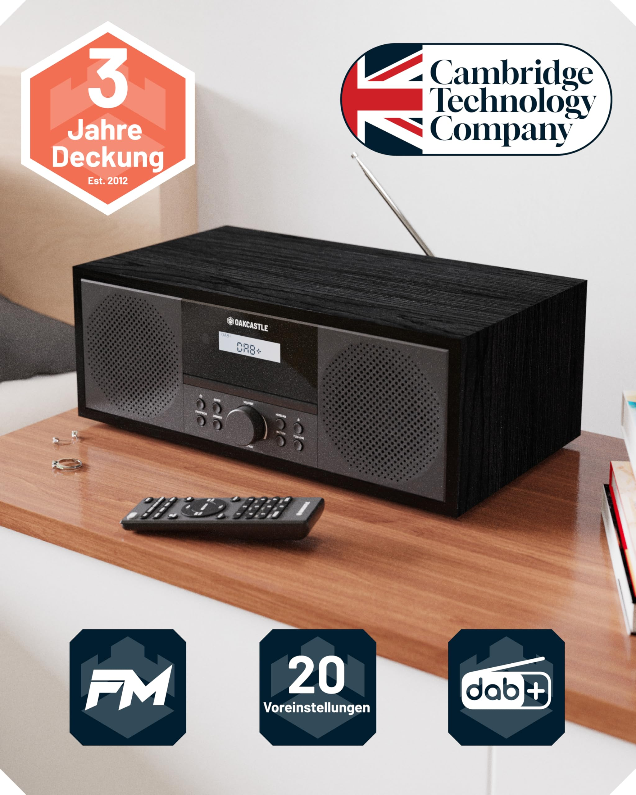 Schwarzes Oakcastle Radio auf Holztisch mit Fernbedienung, Markenlogos und Funktionssymbolen.