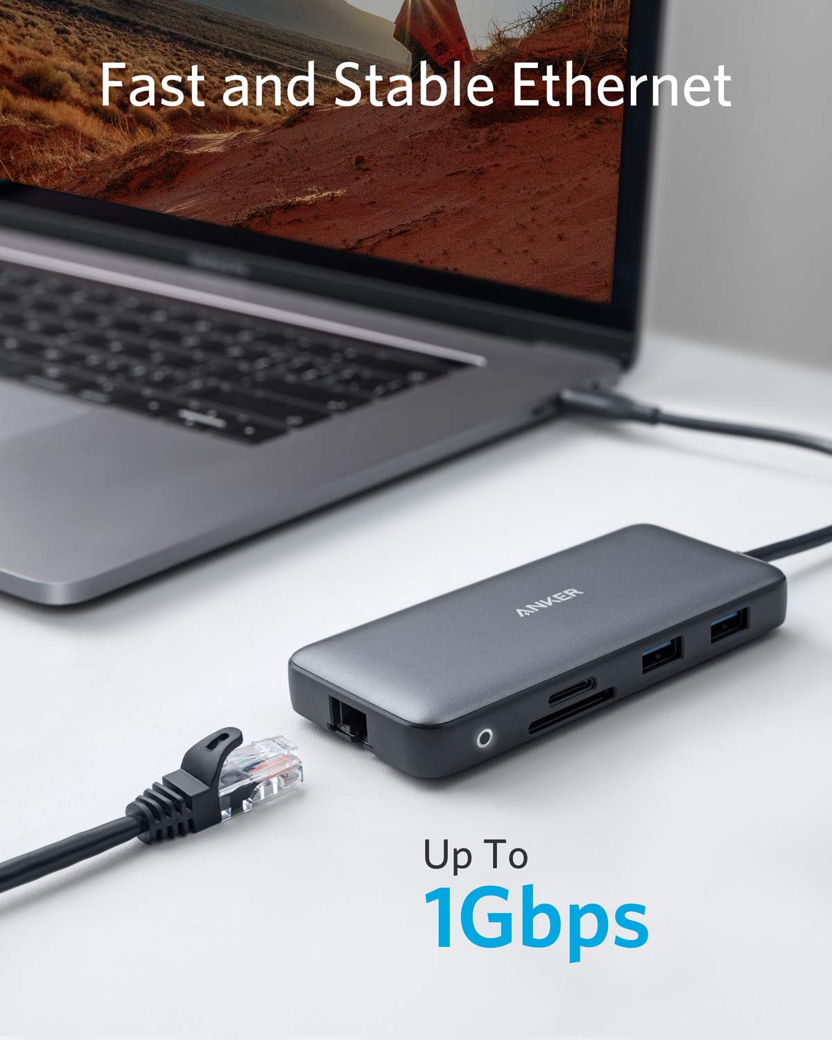 Hub USB-C Anker su una scrivania accanto a un laptop, con un cavo Ethernet vicino.