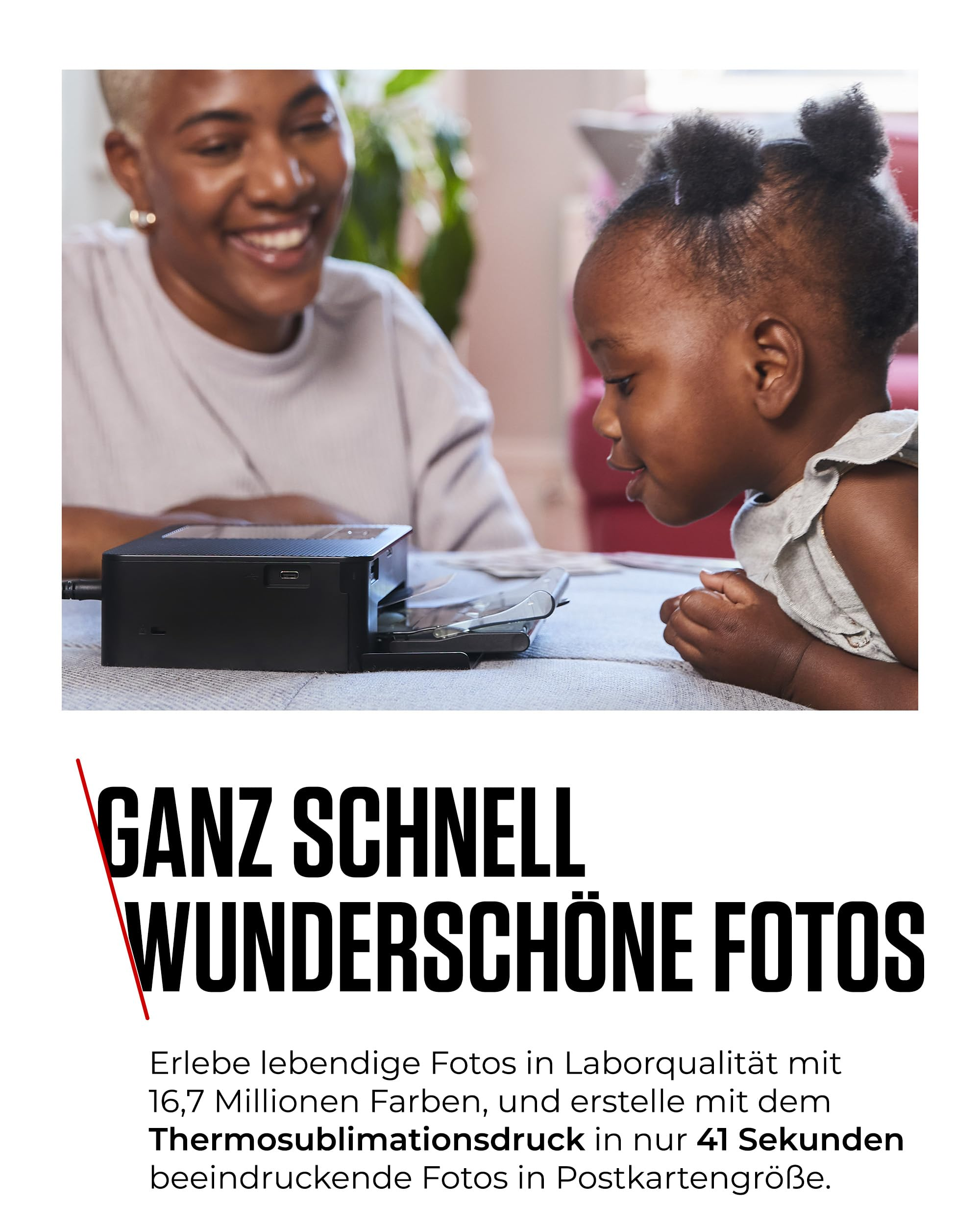 Eine Frau und ein kleines Kind schauen lächelnd auf einen kleinen Fotodrucker.