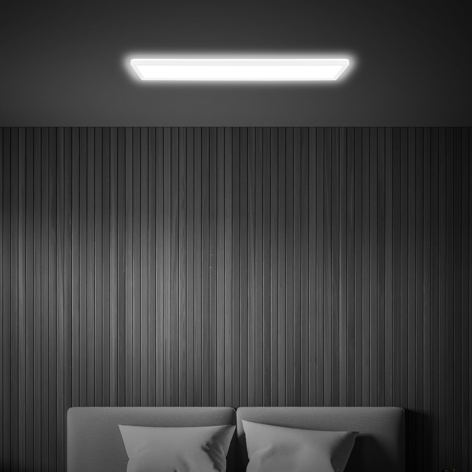 Una plafoniera LED rettangolare illumina sopra una testata grigia contro pareti scure rivestite in legno.