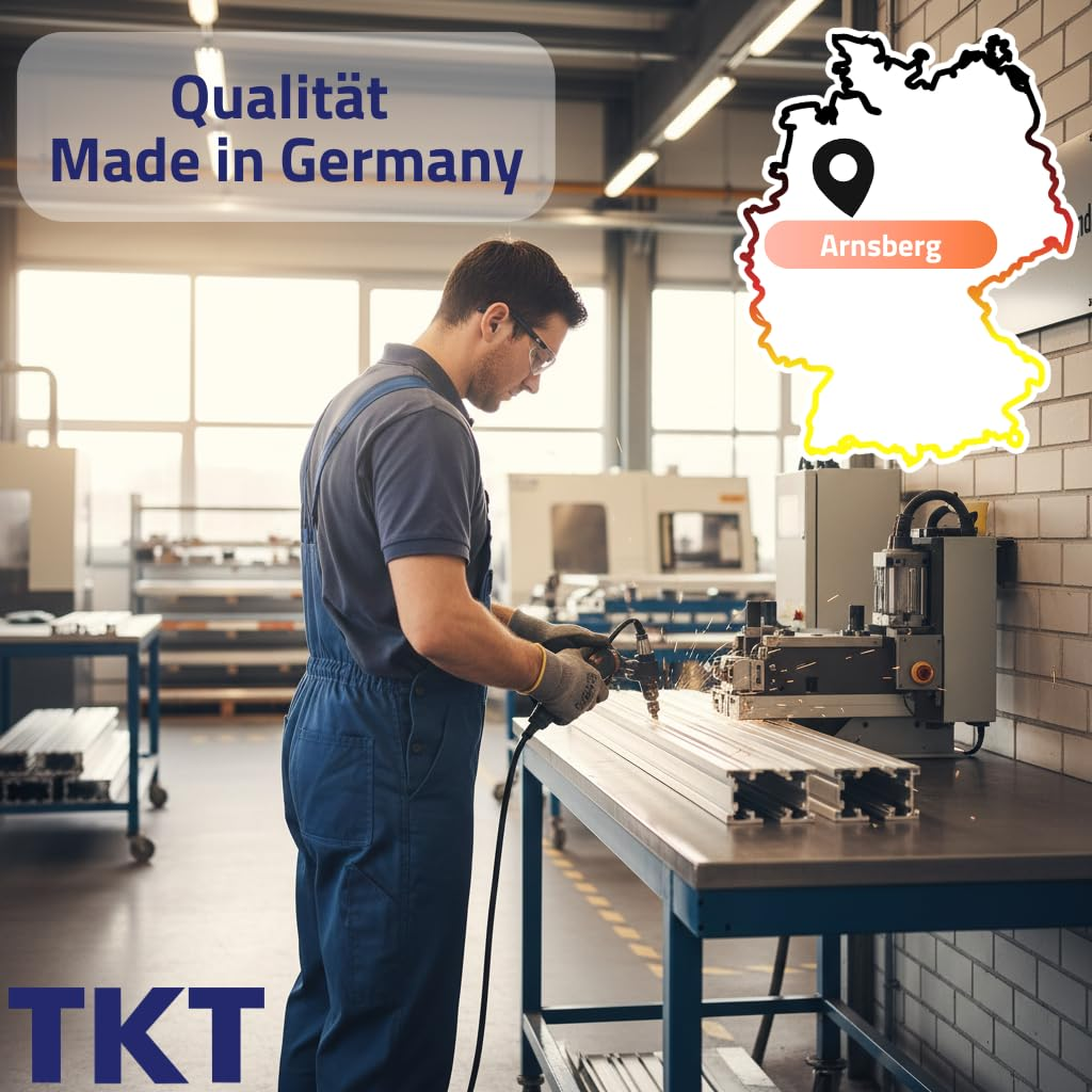Ein Arbeiter in blauer Latzhose schweißt Metall in einer Fabrik mit einer Deutschlandkarte im Hintergrund.
