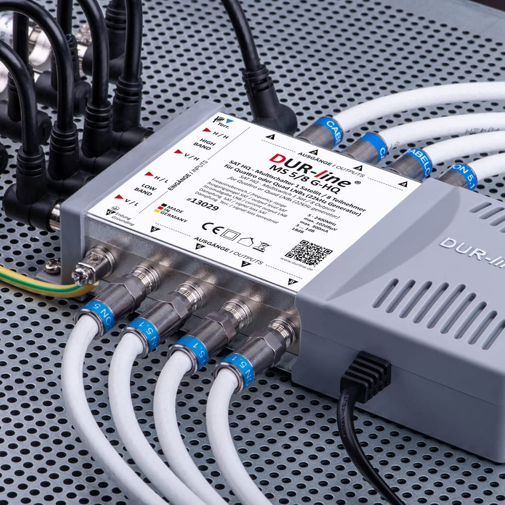 Un commutateur DUR-line gris sur plaque perforée, connecté avec des câbles coaxiaux.