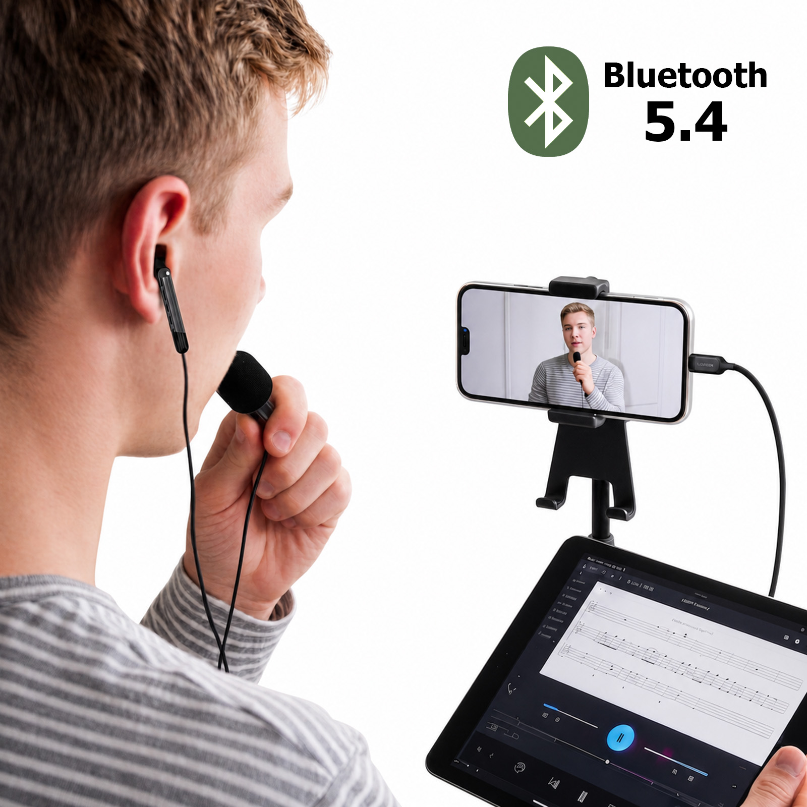 Ein Mann spricht in ein kabelgebundenes Mikrofon, während ein Smartphone und ein Tablet vor ihm stehen.