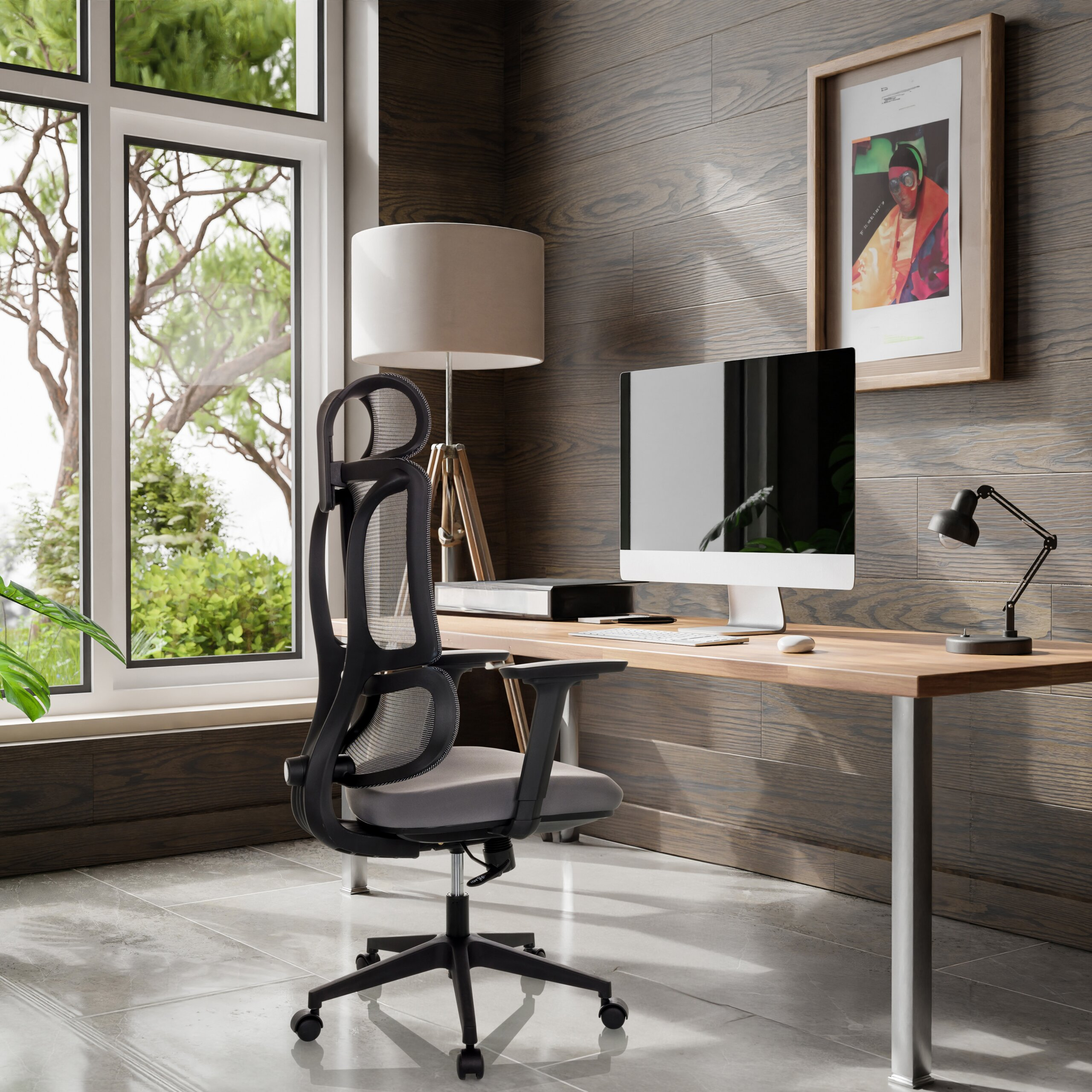 Ein modernes Homeoffice mit Schreibtisch, ergonomischem Stuhl, Stehlampe und großem Fenster mit Blick ins Grüne.