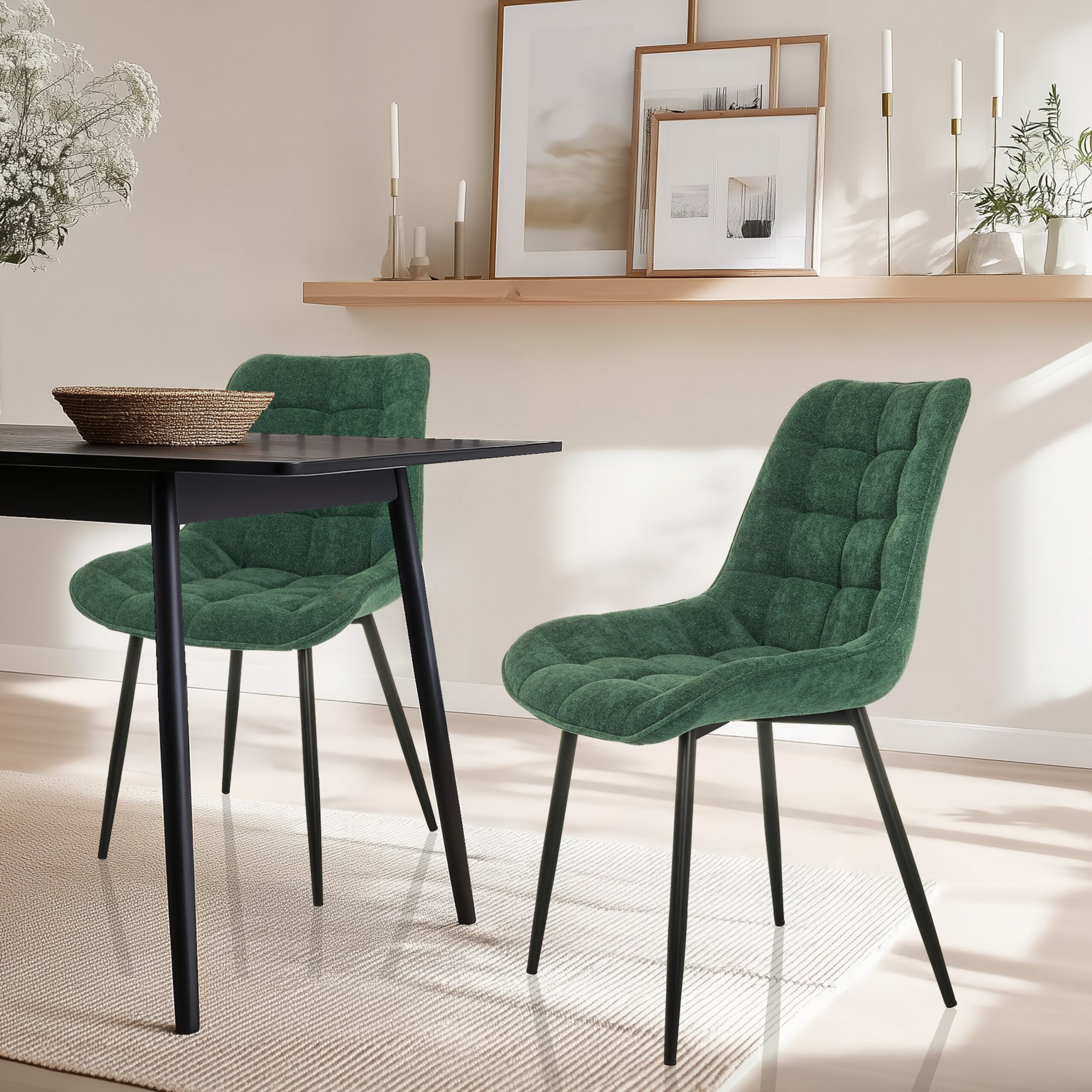 Zwei grüne gepolsterte Stühle mit schwarzen Beinen stehen an einem dunklen Tisch auf einem Teppich.