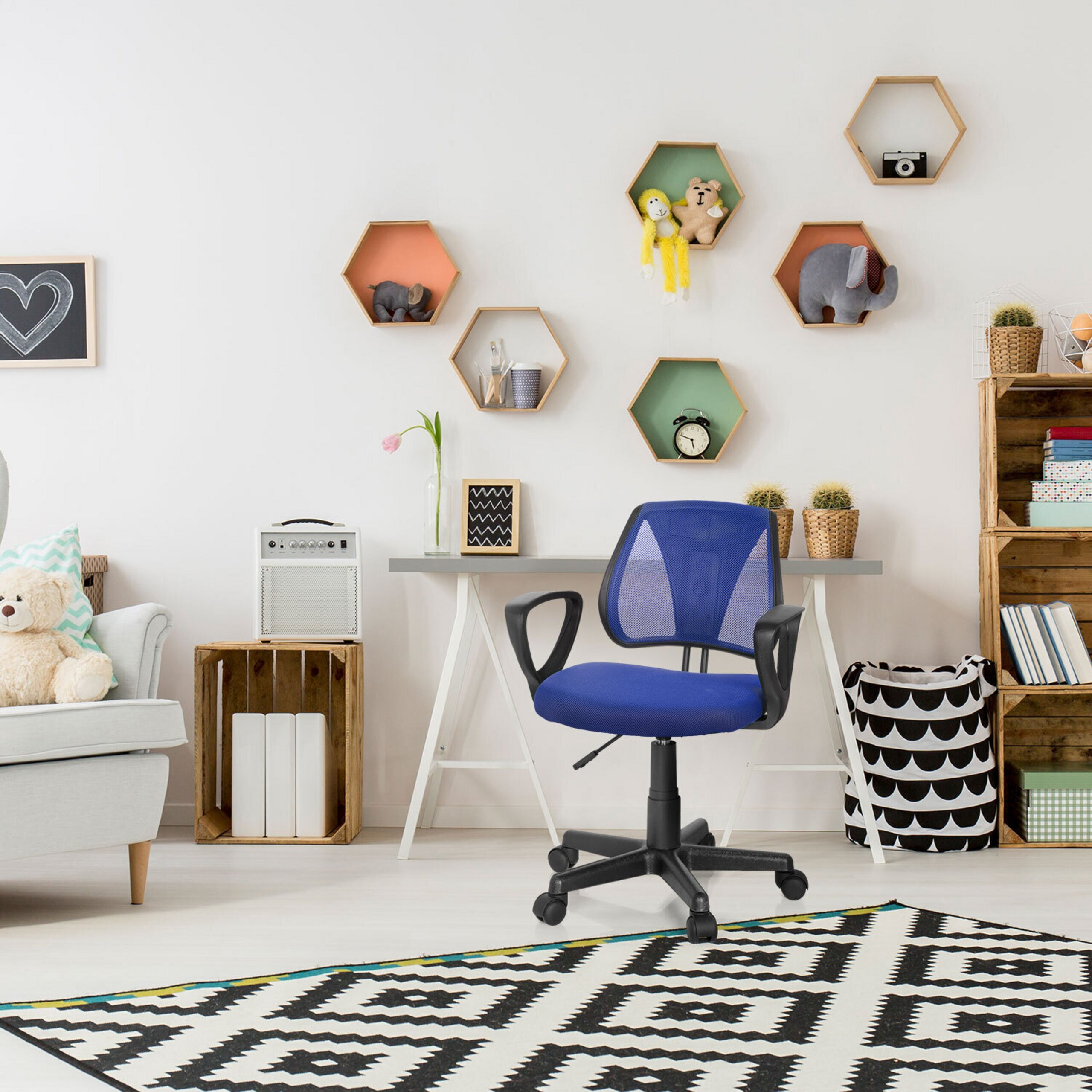Ein blauer Buerostuhl steht vor einem Tisch im Kinderzimmer mit Hexagon-Wandregalen und Teppich.