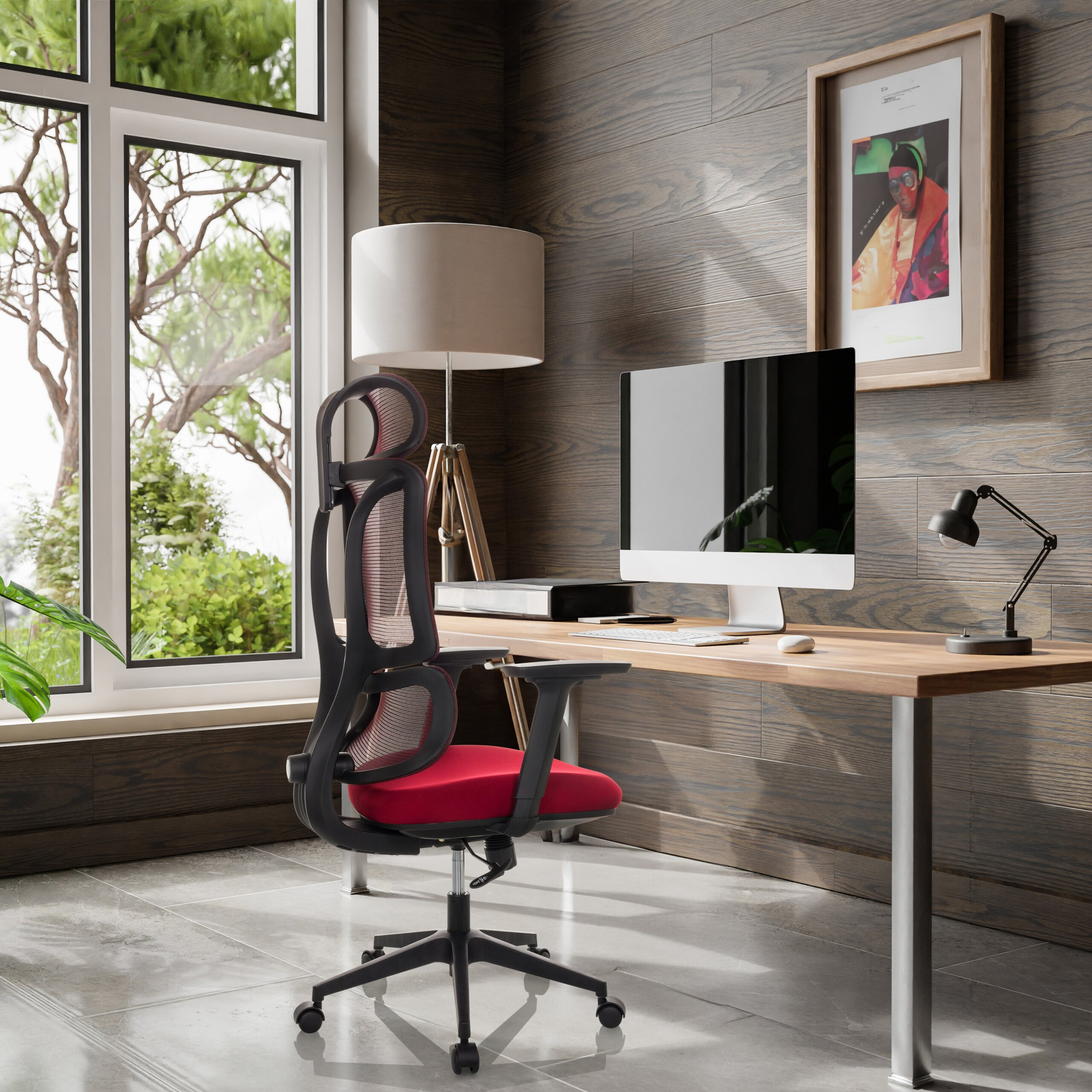 Büro mit Holzwand, Schreibtisch, rotem Stuhl, Computer und großem Fenster mit Blick auf Bäume.