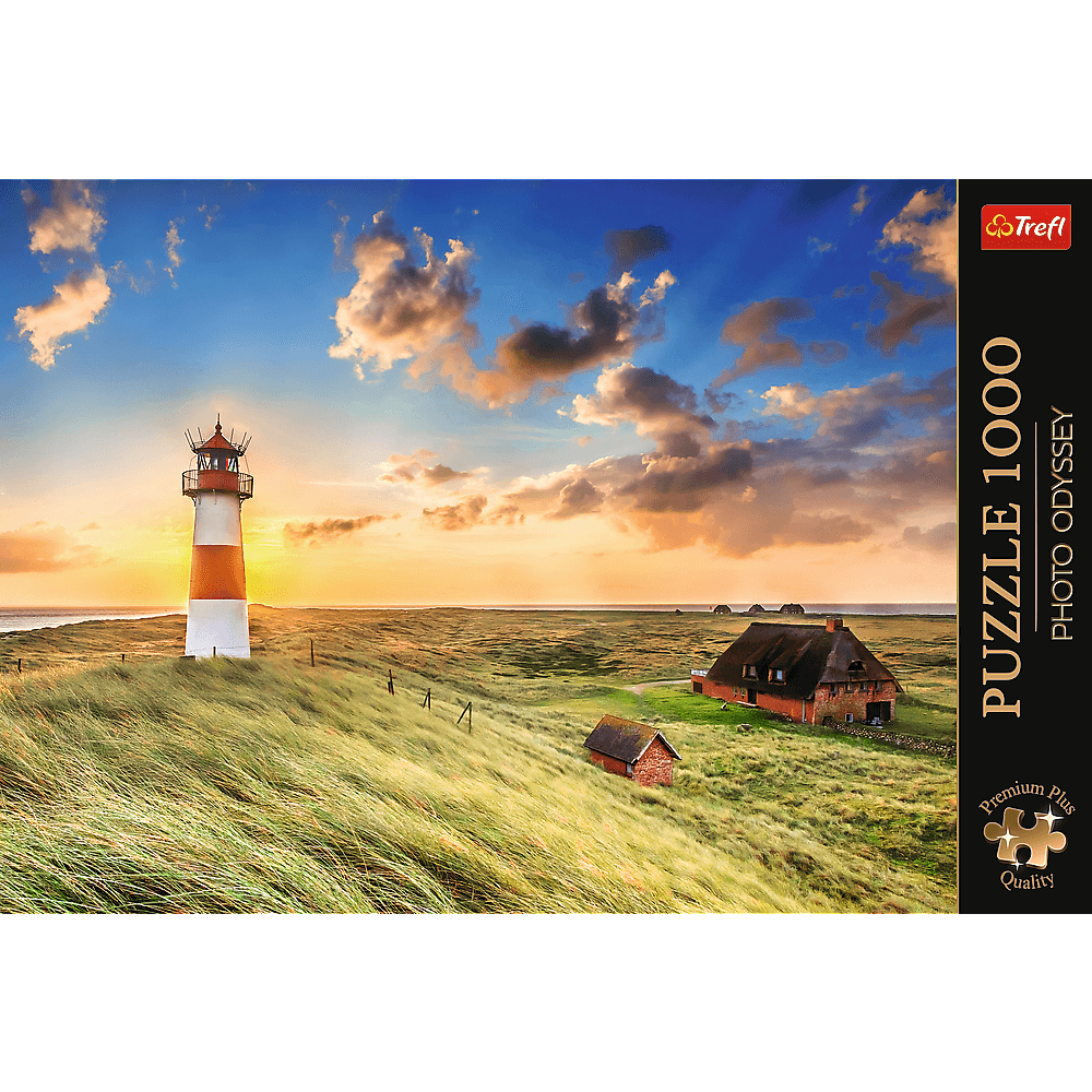 Ein Leuchtturm und Häuser in einer Küstenlandschaft bei Sonnenuntergang.